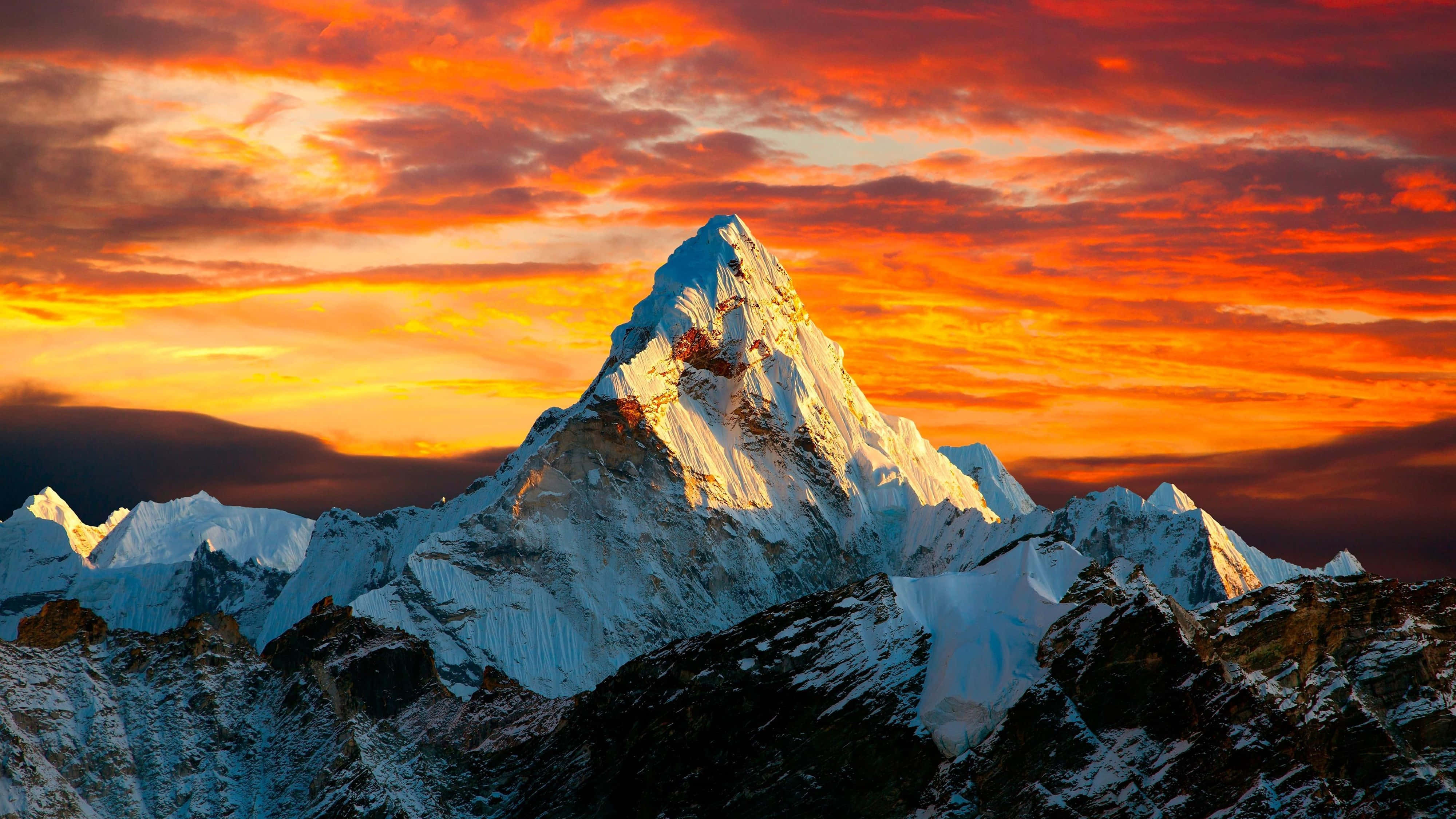 4K Berg onder Oranjerige Lug Muurpapier