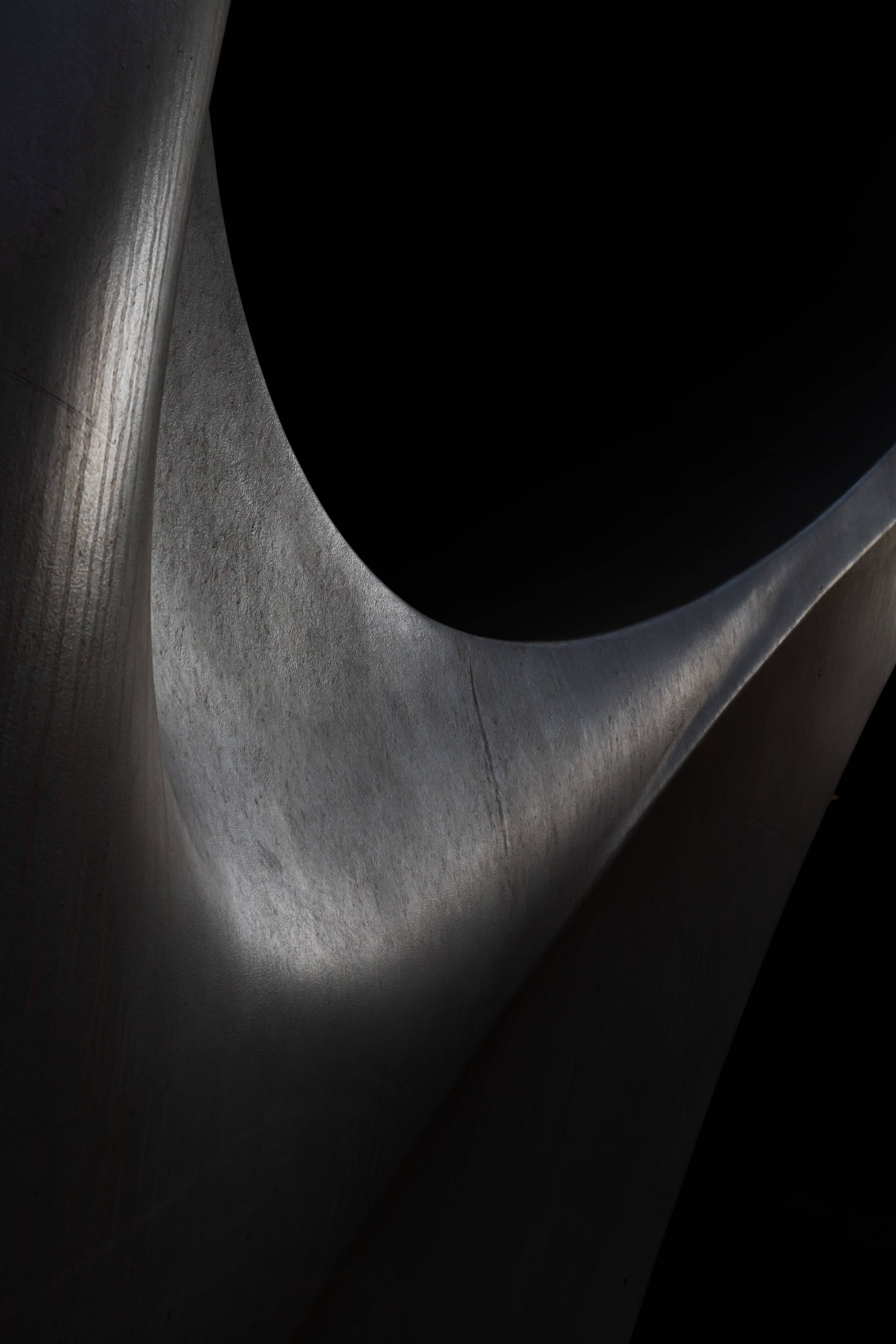 Abstracte swart beeldhouwerk in 'n dowwe kamer Muurpapier