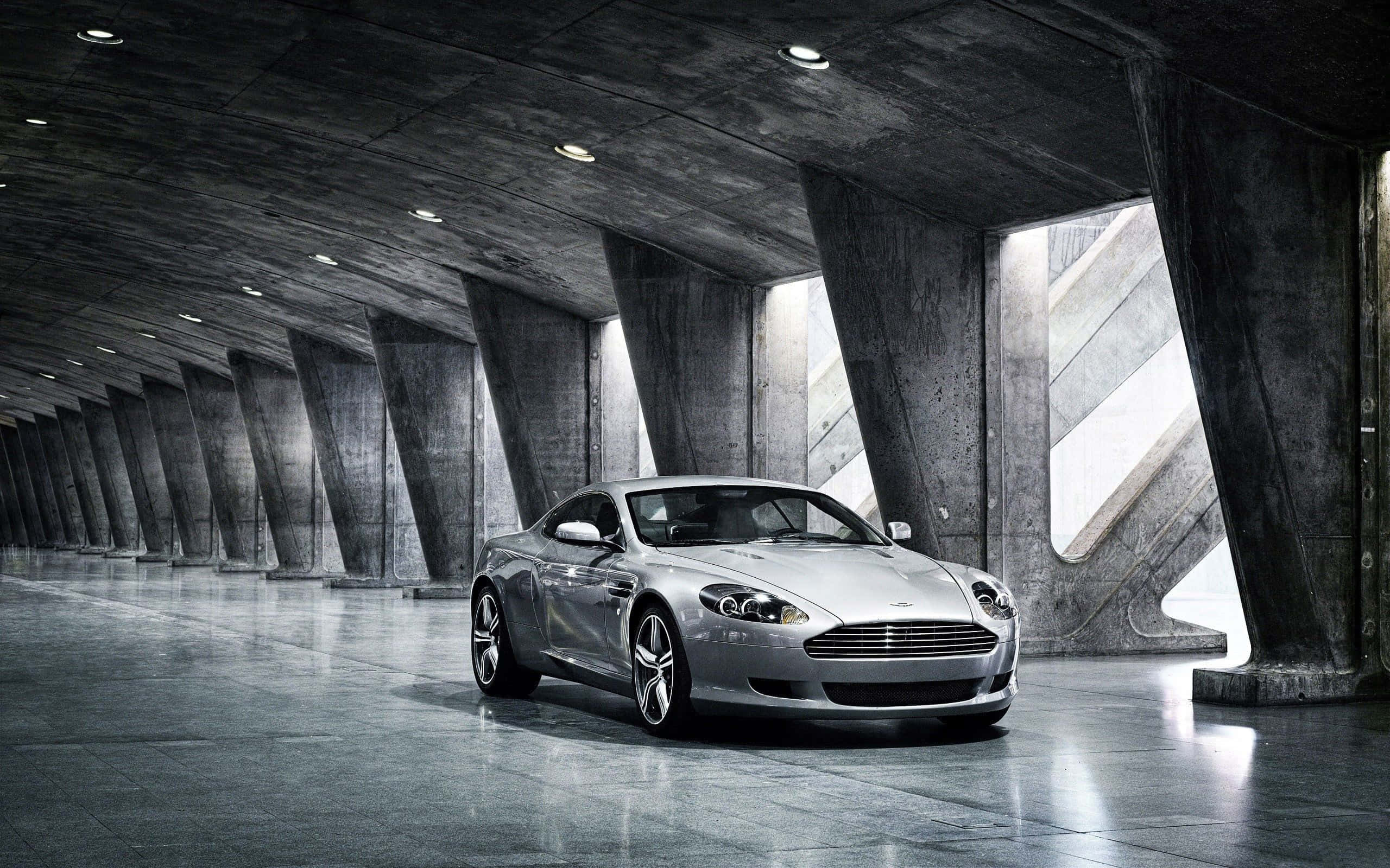 Aston Martin DB9 wat deur 'n Skilderagtige Stadsbeeld Kruis Muurpapier