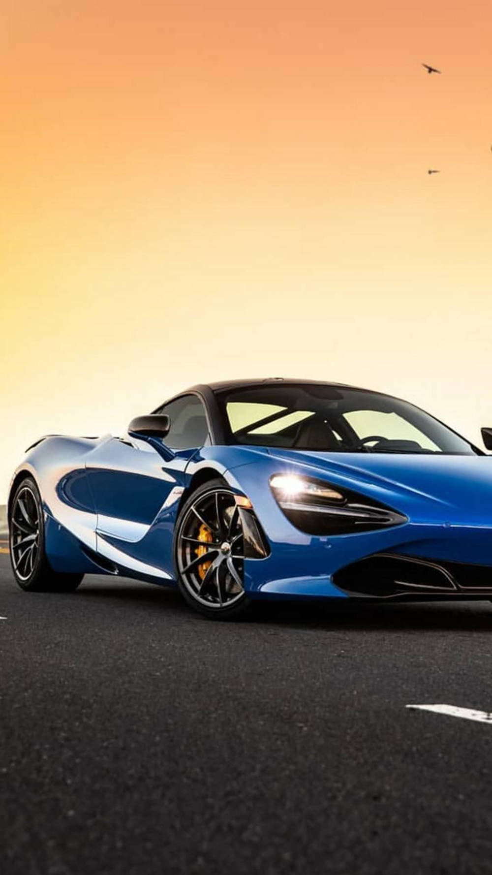 Blou McLaren 720S onder Sonsondergang Foon Muurpapier