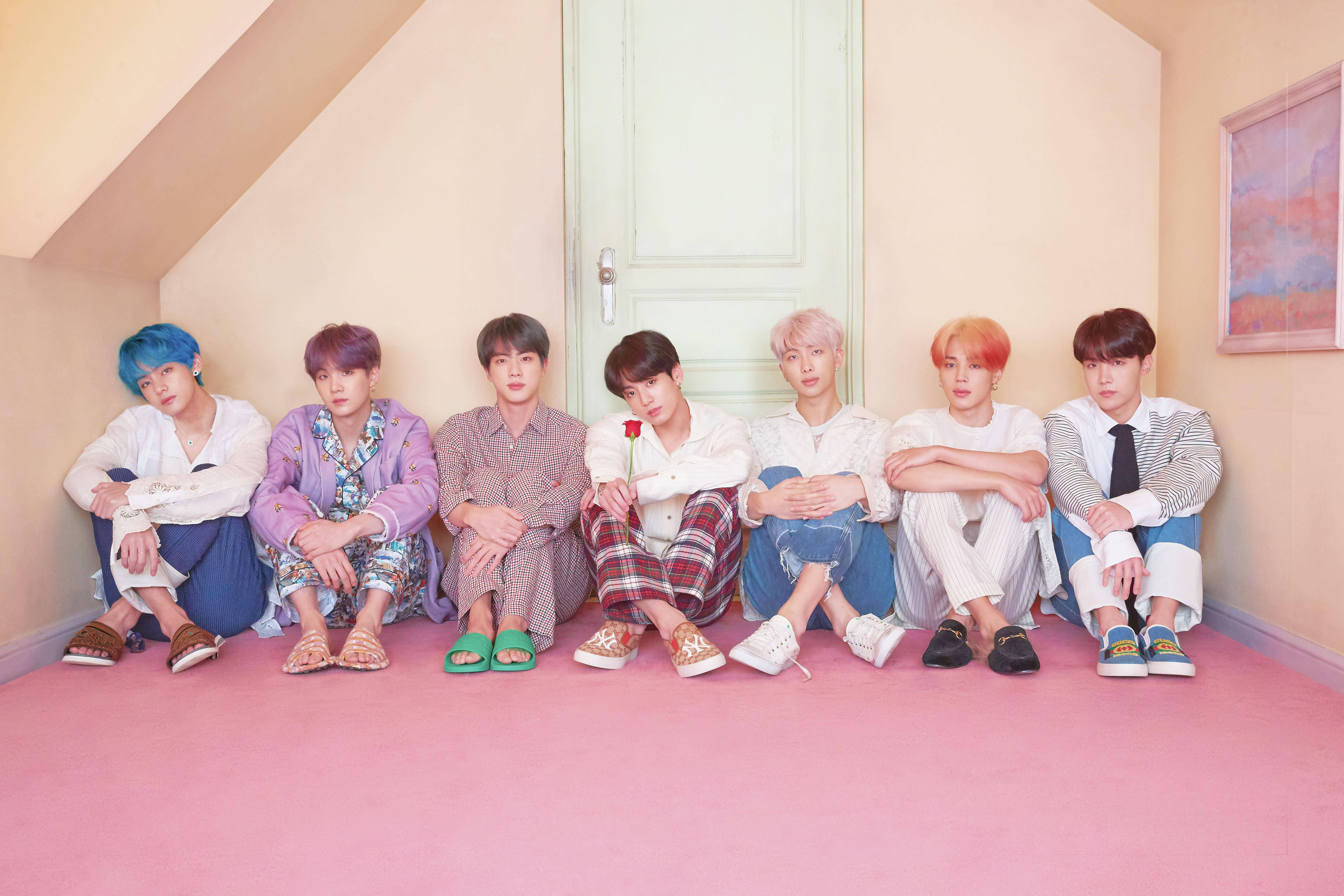 BTS-lessenaar wat voor die deur sit Muurpapier