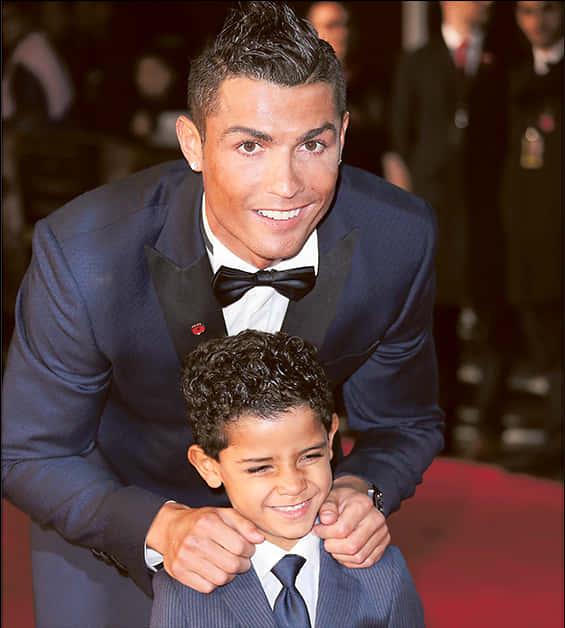 Cristiano Ronaldo glimlag saam met kind by geleentheid Muurpapier