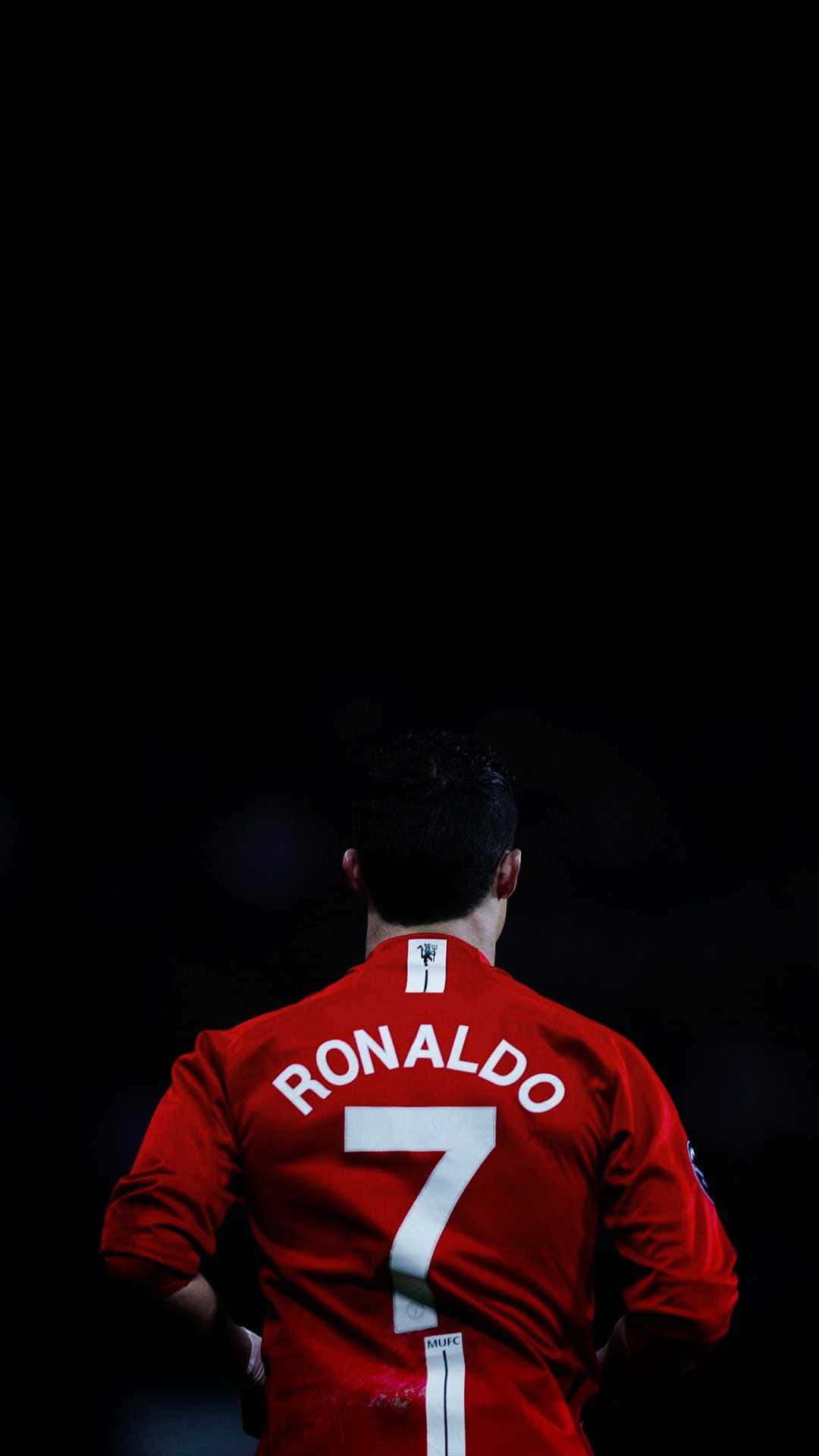 Cristiano Ronaldo wat 'n kragtige skop op die veld neem Muurpapier