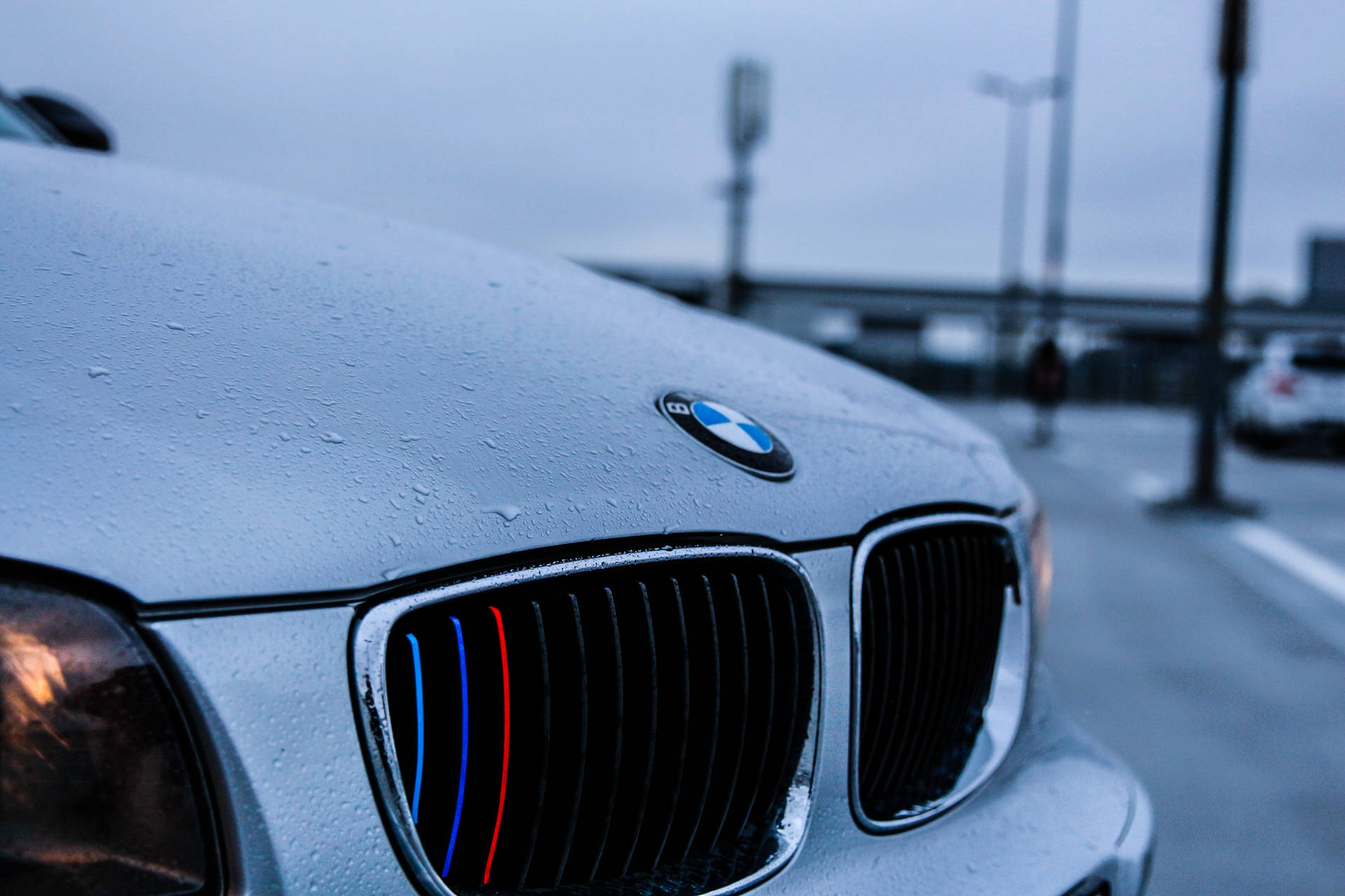 Nabyfoto agtergrond van wit BMW-motor-enjinkap met reëndruppels
