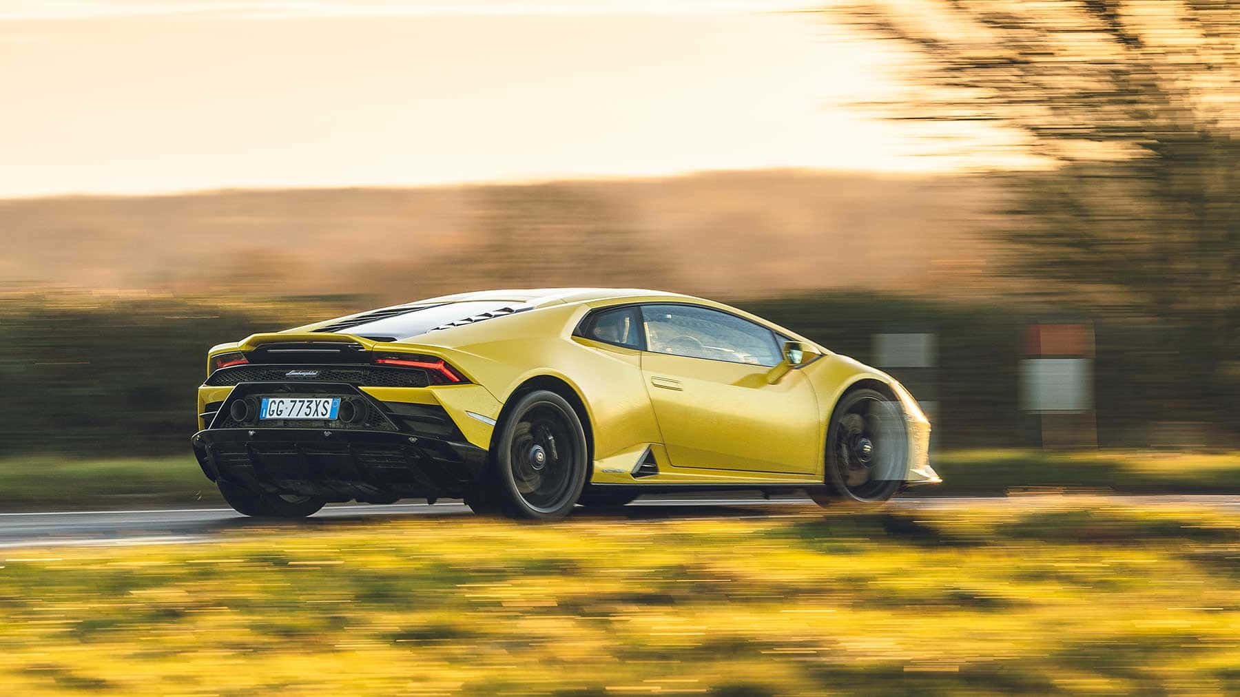 Die Lamborghini Huracan ry op 'n plattelandse pad af Muurpapier