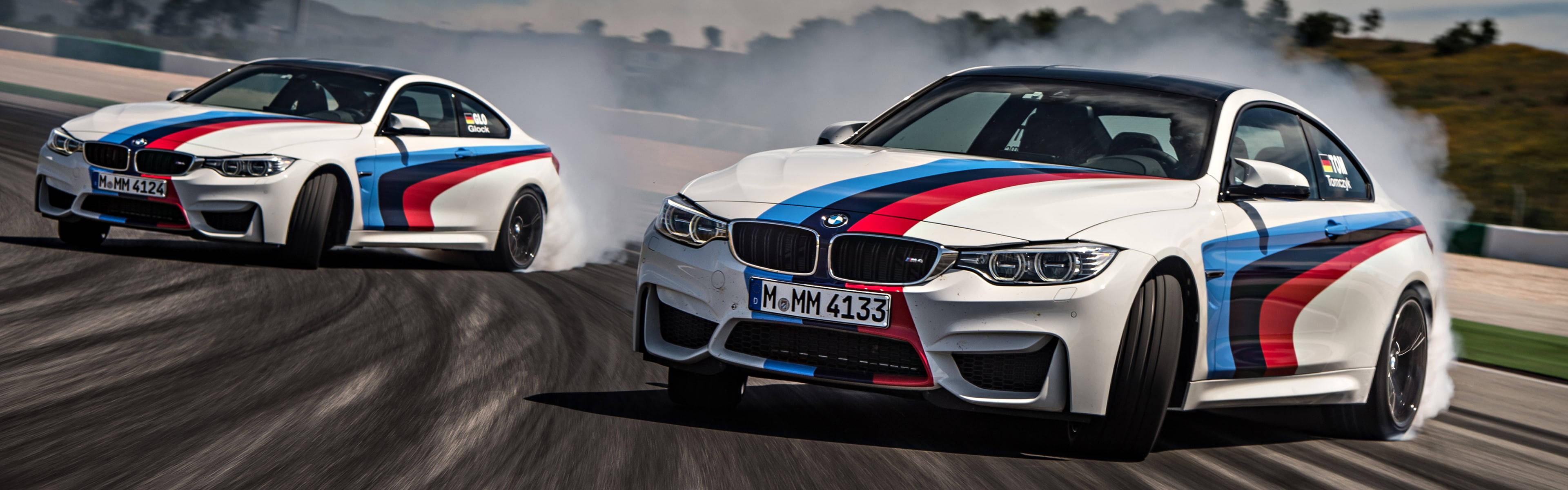 Die opwindende rit van 'n BMW M4-dryfmotor op die baan Muurpapier