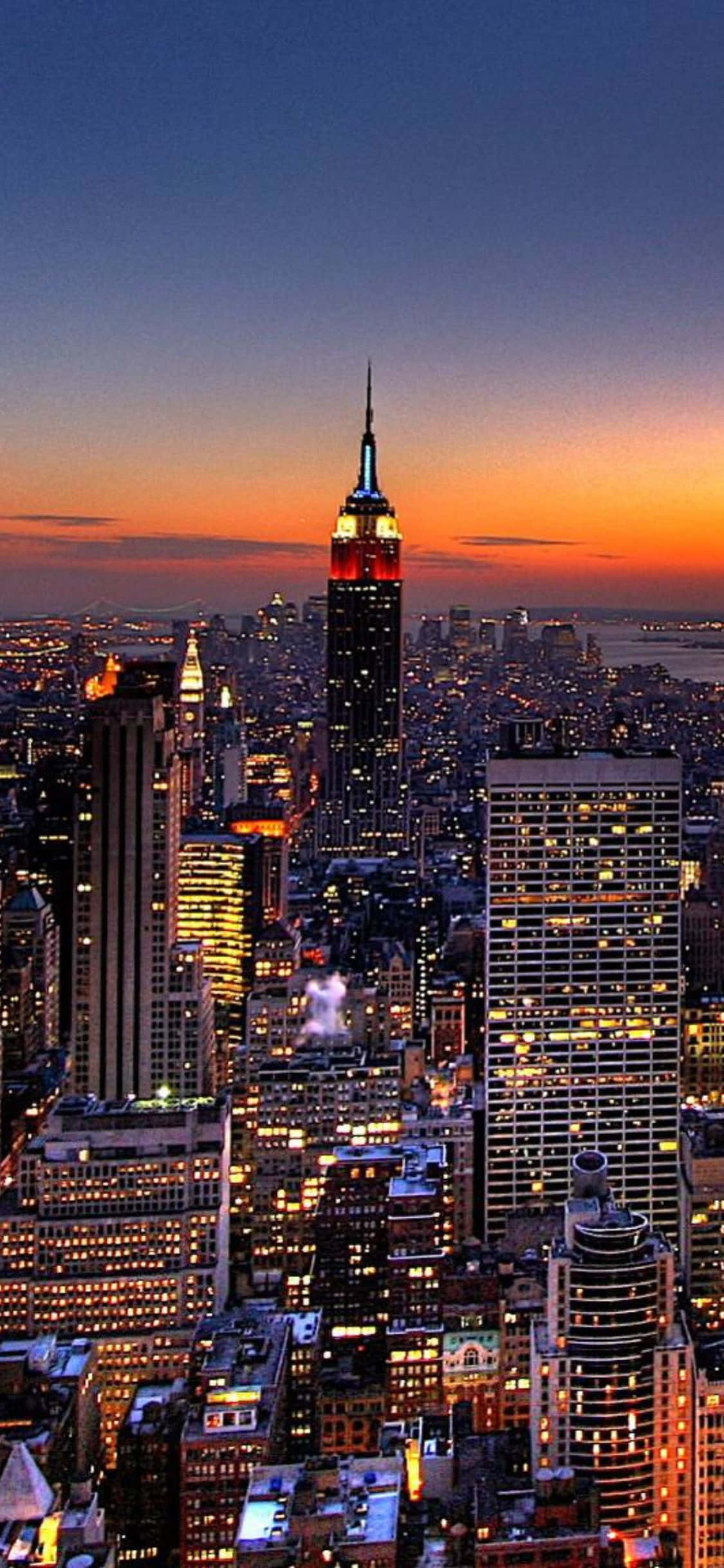 Die skyline van New York glinster met die silhoeët van 'n iPhone X Muurpapier