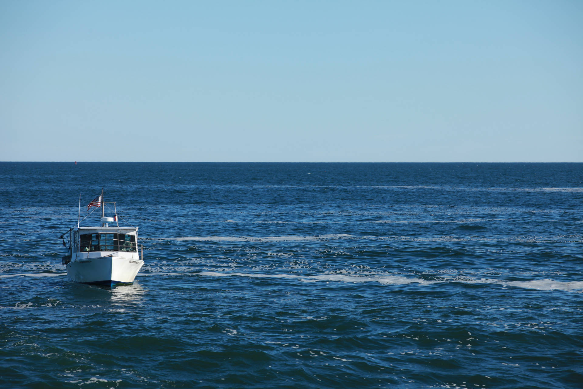 Boot in 'n groot blou oseaan met golwe op 'n helder weer. — Oseaan Muurpapier