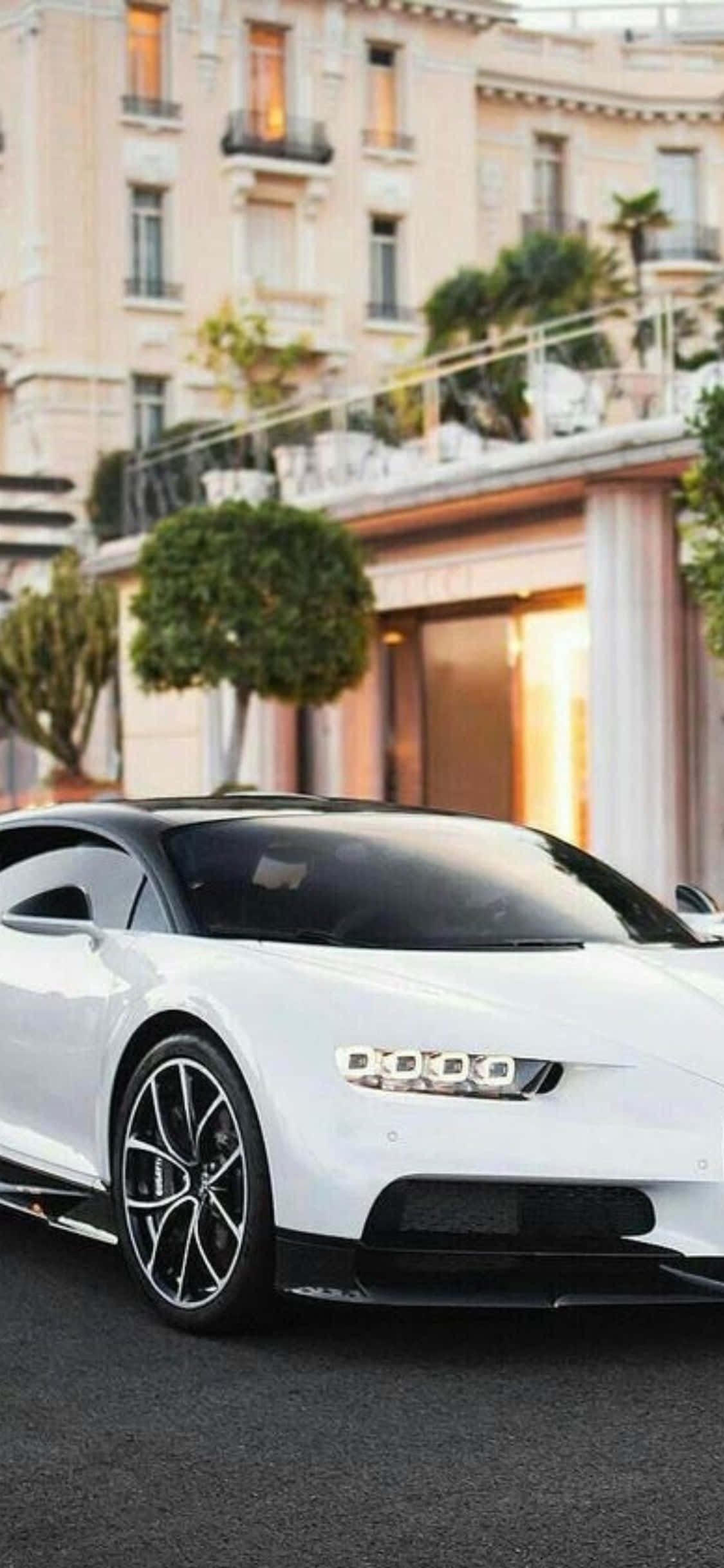 die wit bugatti chiron is voor 'n gebou geparkeer Muurpapier