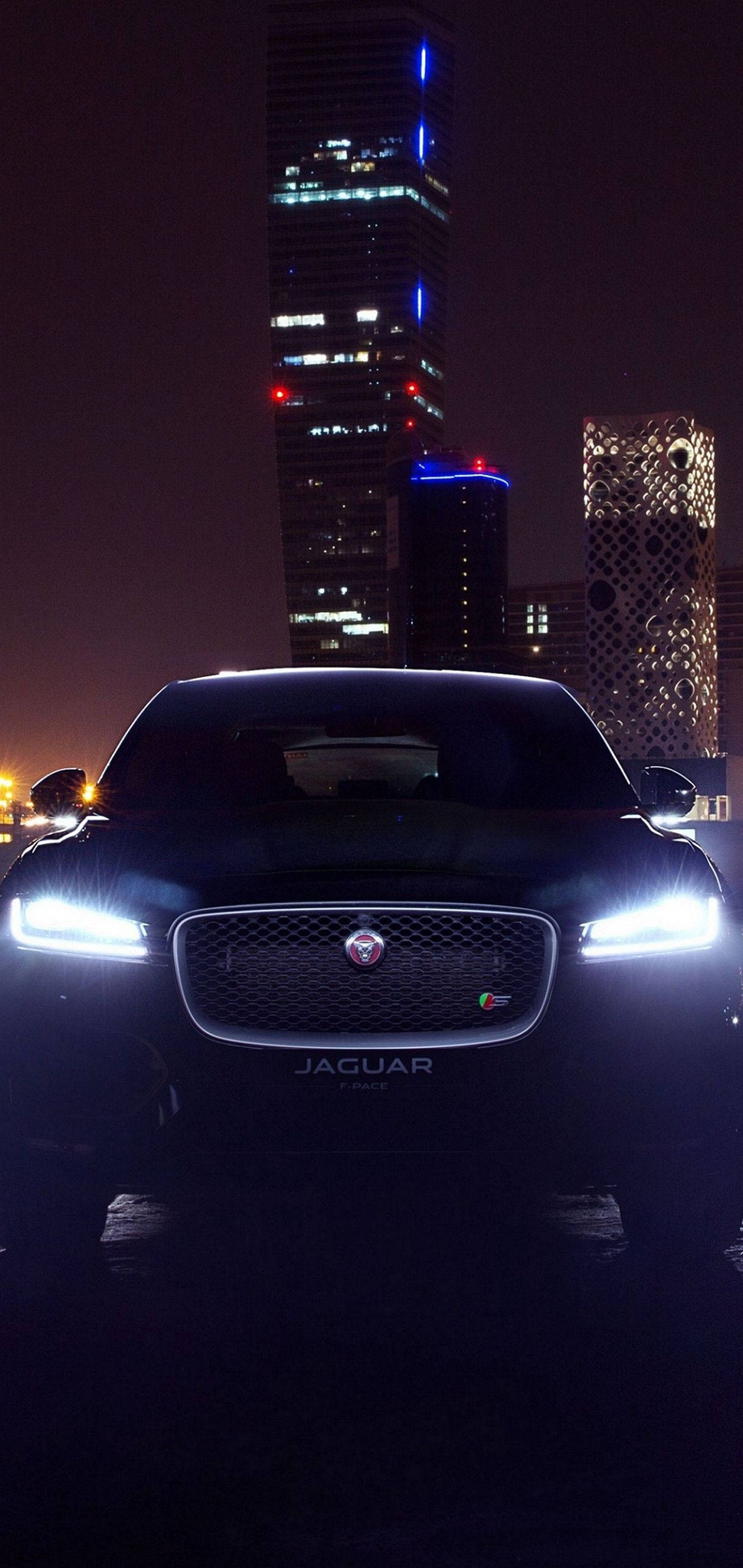 Ervaar die krag en elegansie van 'n Jaguar-motor in die nag Muurpapier
