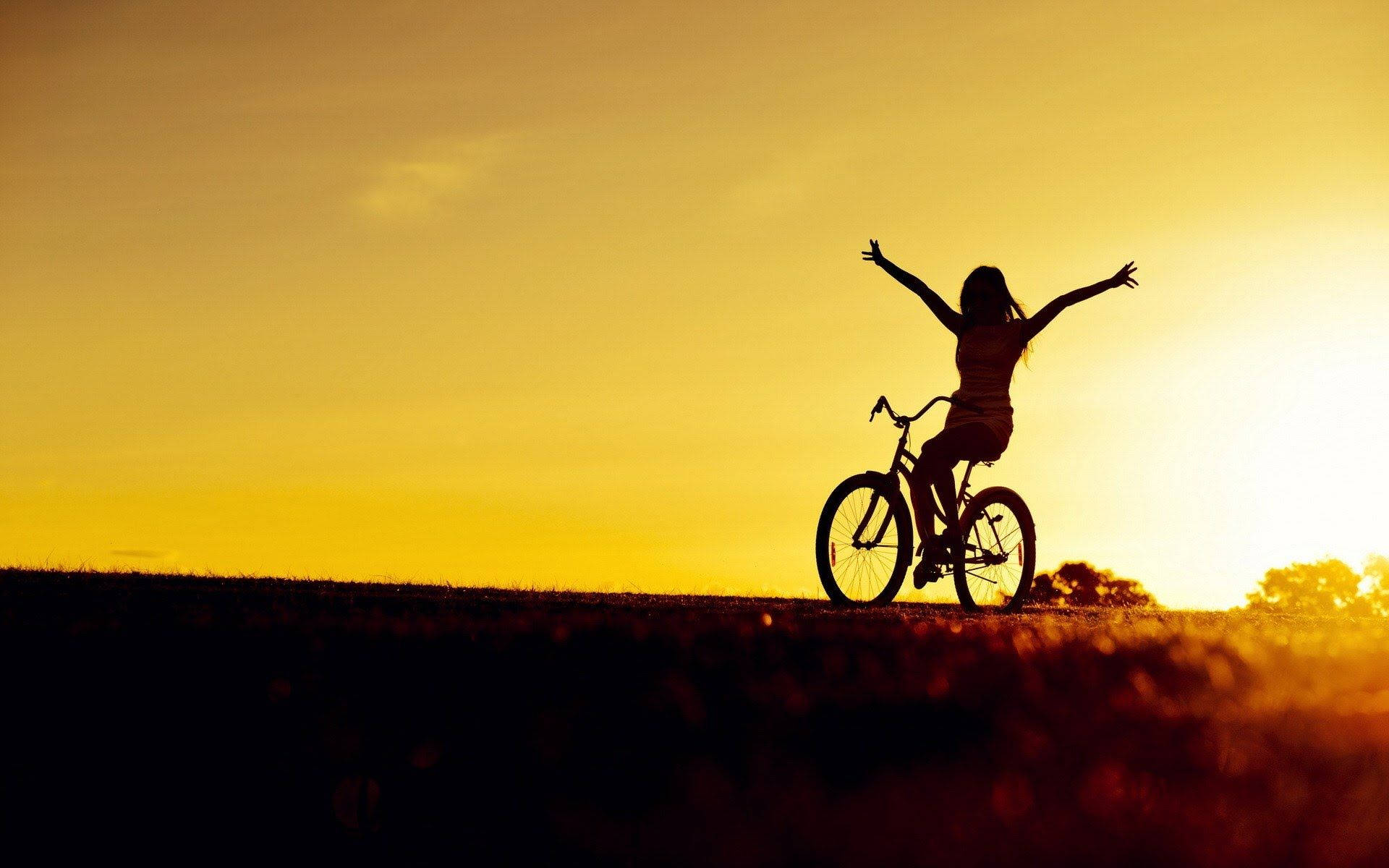 Fietsliefhebber se Silhouet Teen 'n Sonsondergang Muurpapier