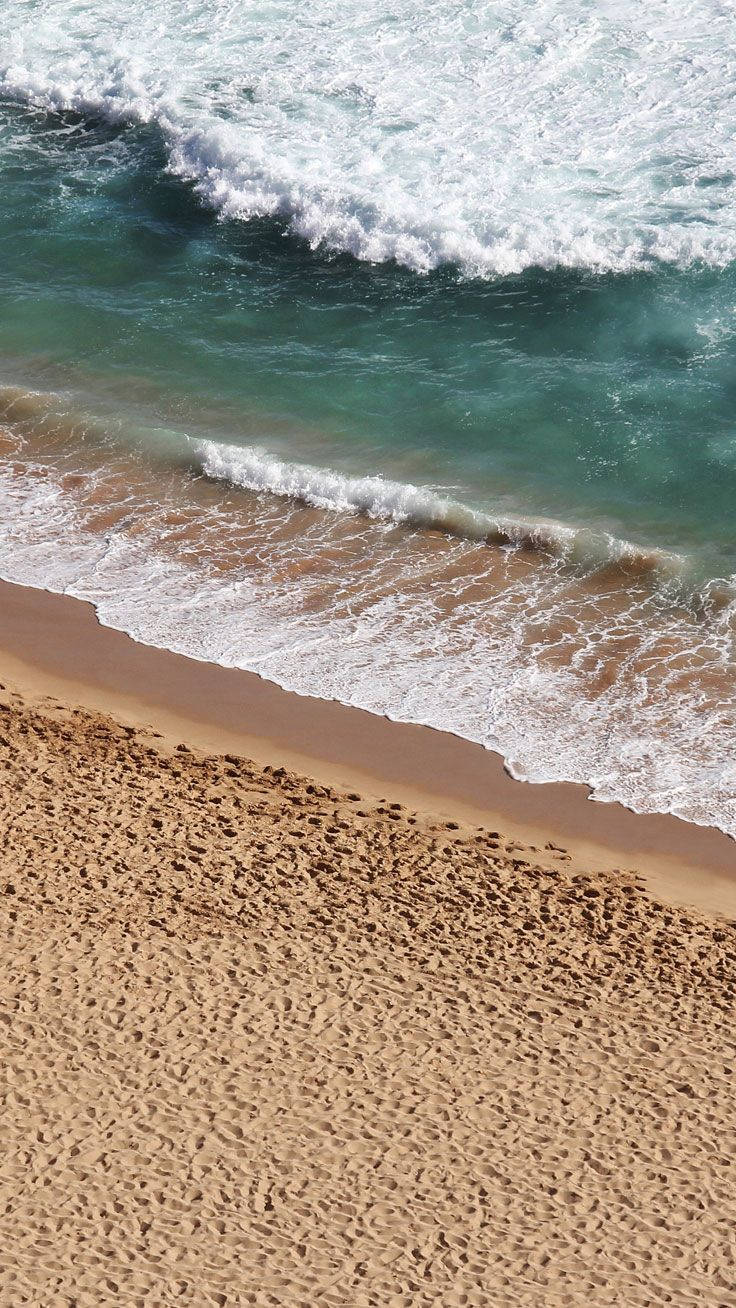 Oseaan golwe wat breek op die strand Iphone-agtergrond