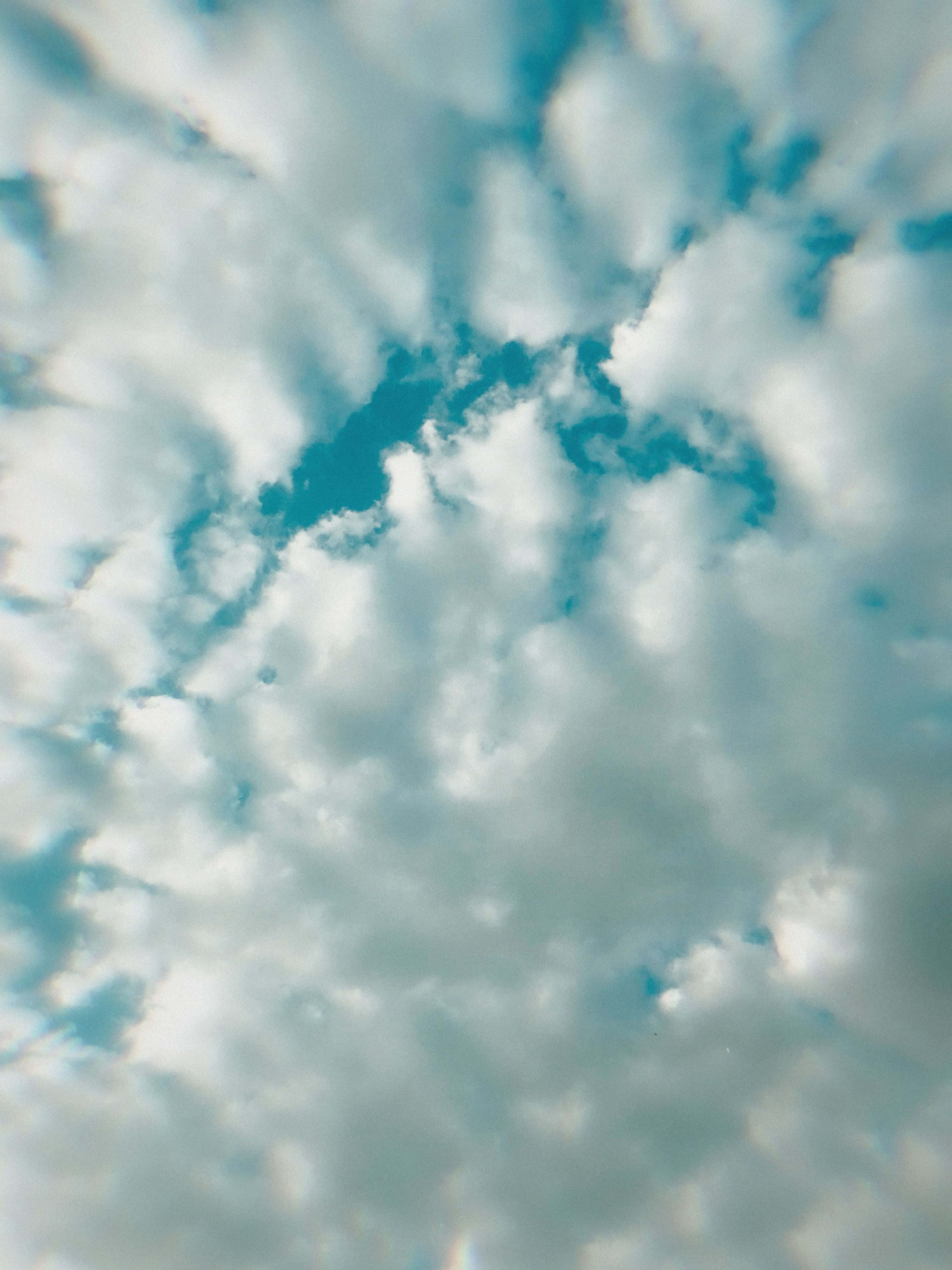 Geniet 'n rustige oomblik terwyl jy die pragtige uitsig van die helder blou lug met wit wolke inneem. Muurpapier