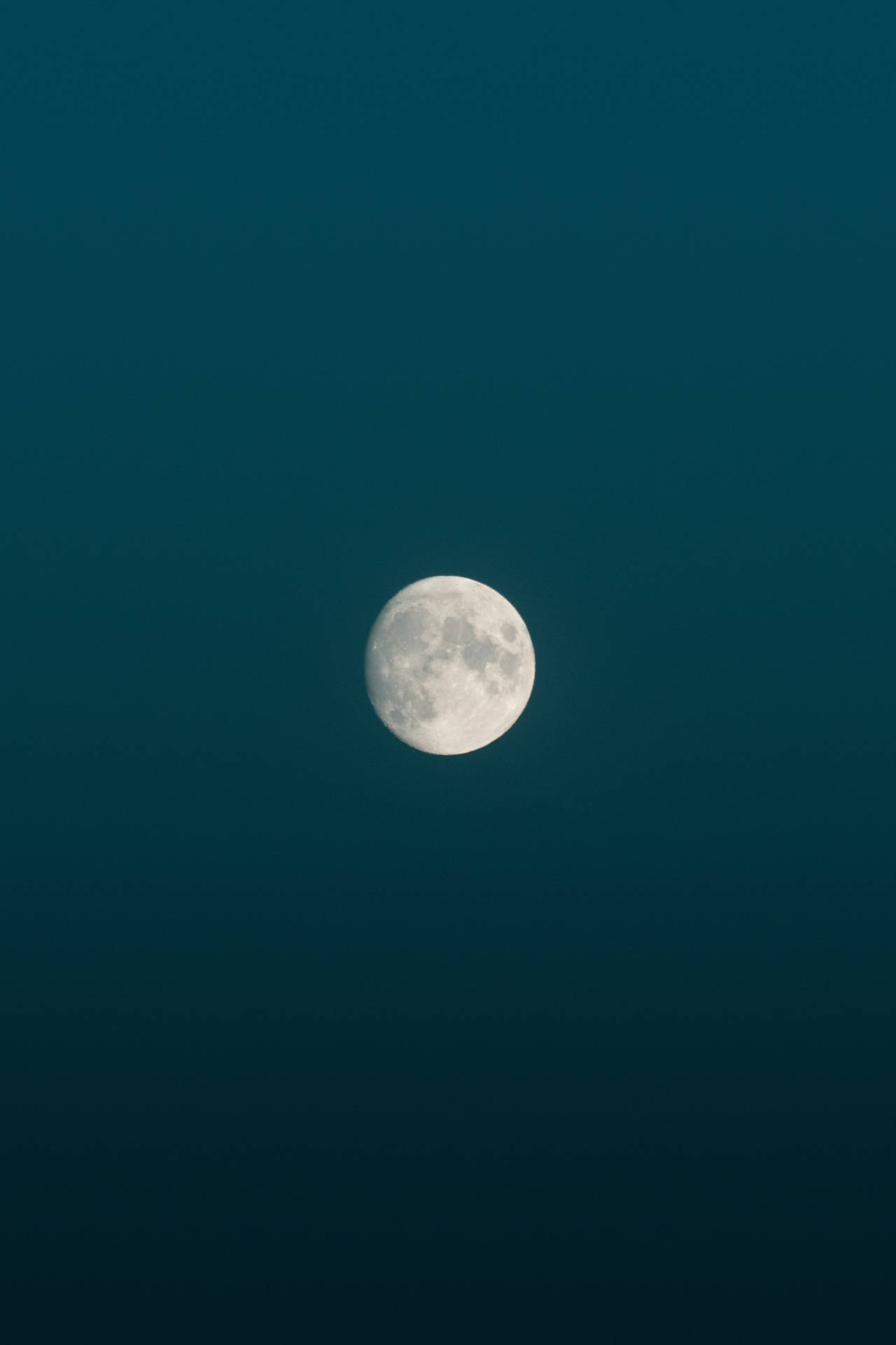 Helderheid van volmaan gedurende middernag in 'n blou minimalistiese estetiese lug. Maan en sy sigbare oppervlak.