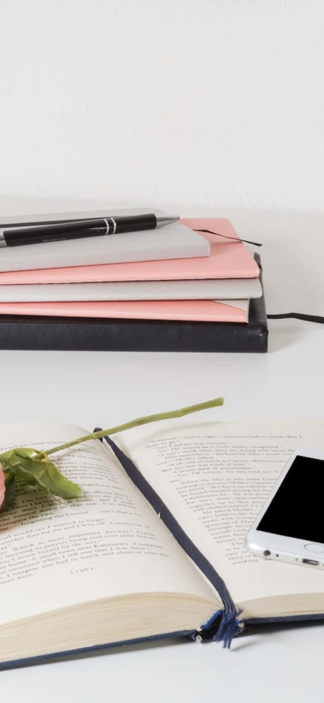 iPhone X Lessenaaragtergrond Stapels Papier met 'n Oop Notaboek Muurpapier