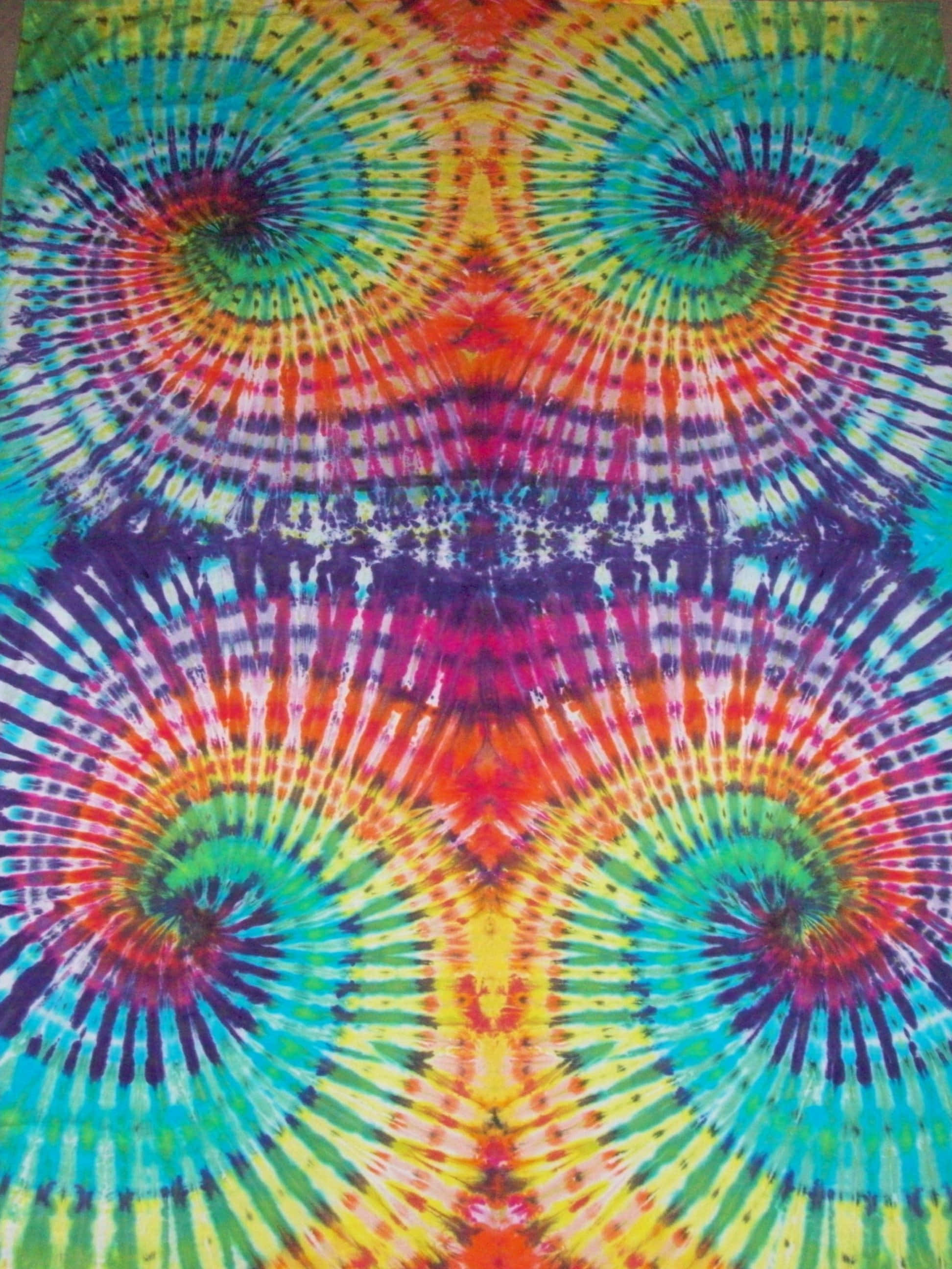 kleurvolle tie-dye kombers met 'n spiraalpatroon Muurpapier