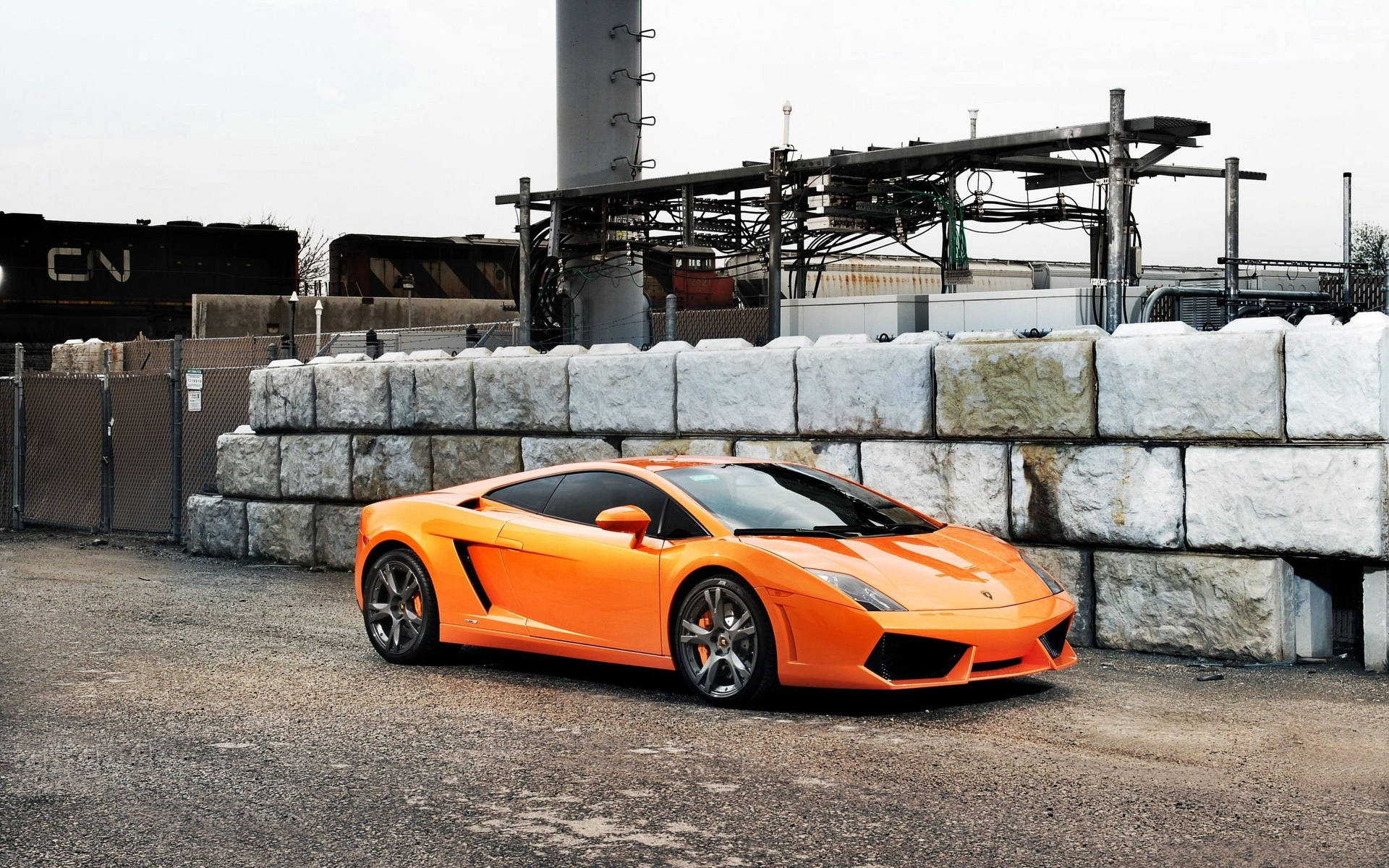 Oranje Lamborghini Gallardo op industriële gebied agtergrond.