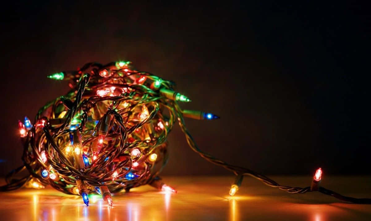 Magiese Kersfeesliggies wat om 'n winterboom hang Muurpapier