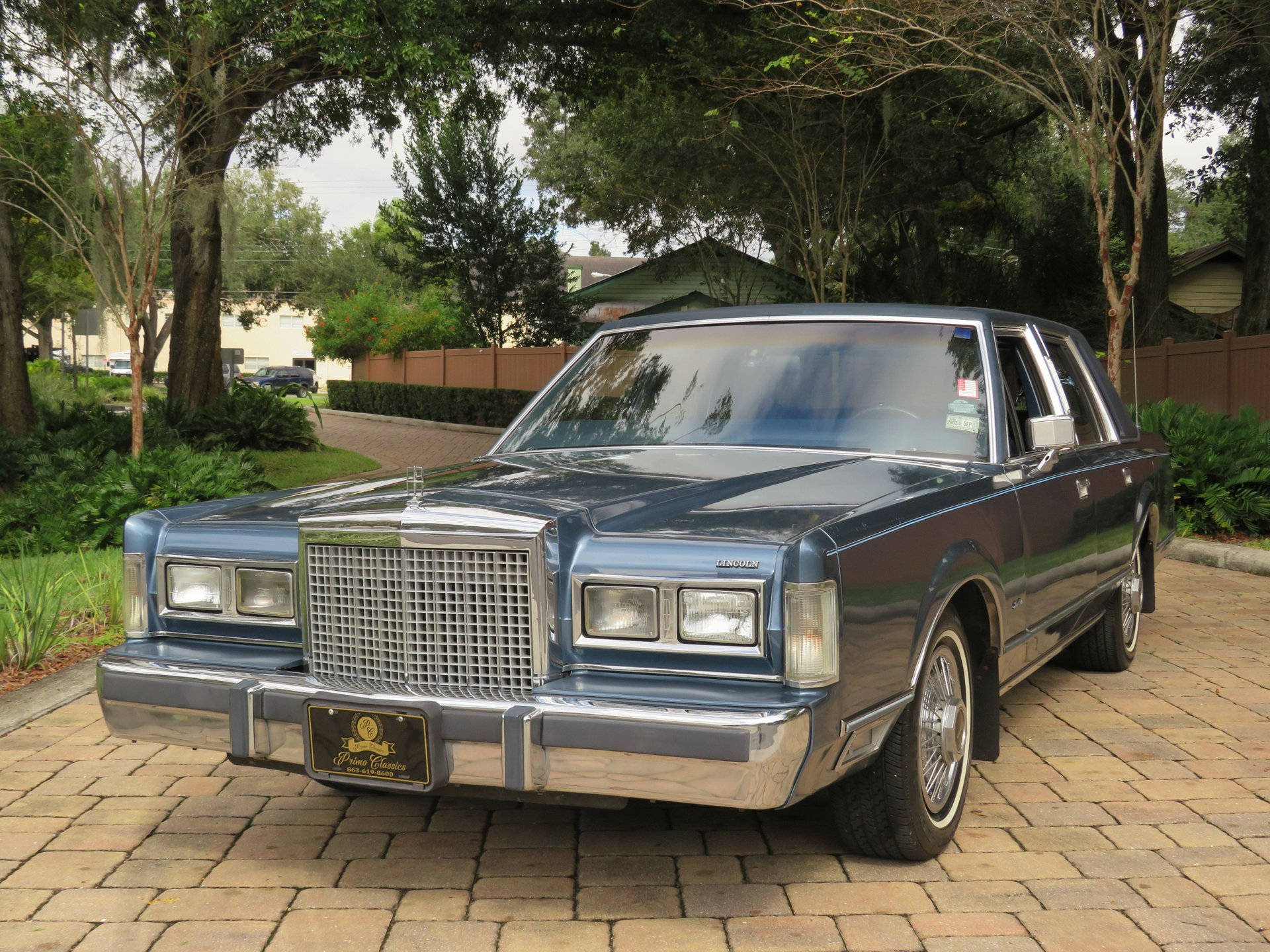 Majestueuse 1986 Lincoln Town Car geparkeer op 'n Teeroprit Muurpapier