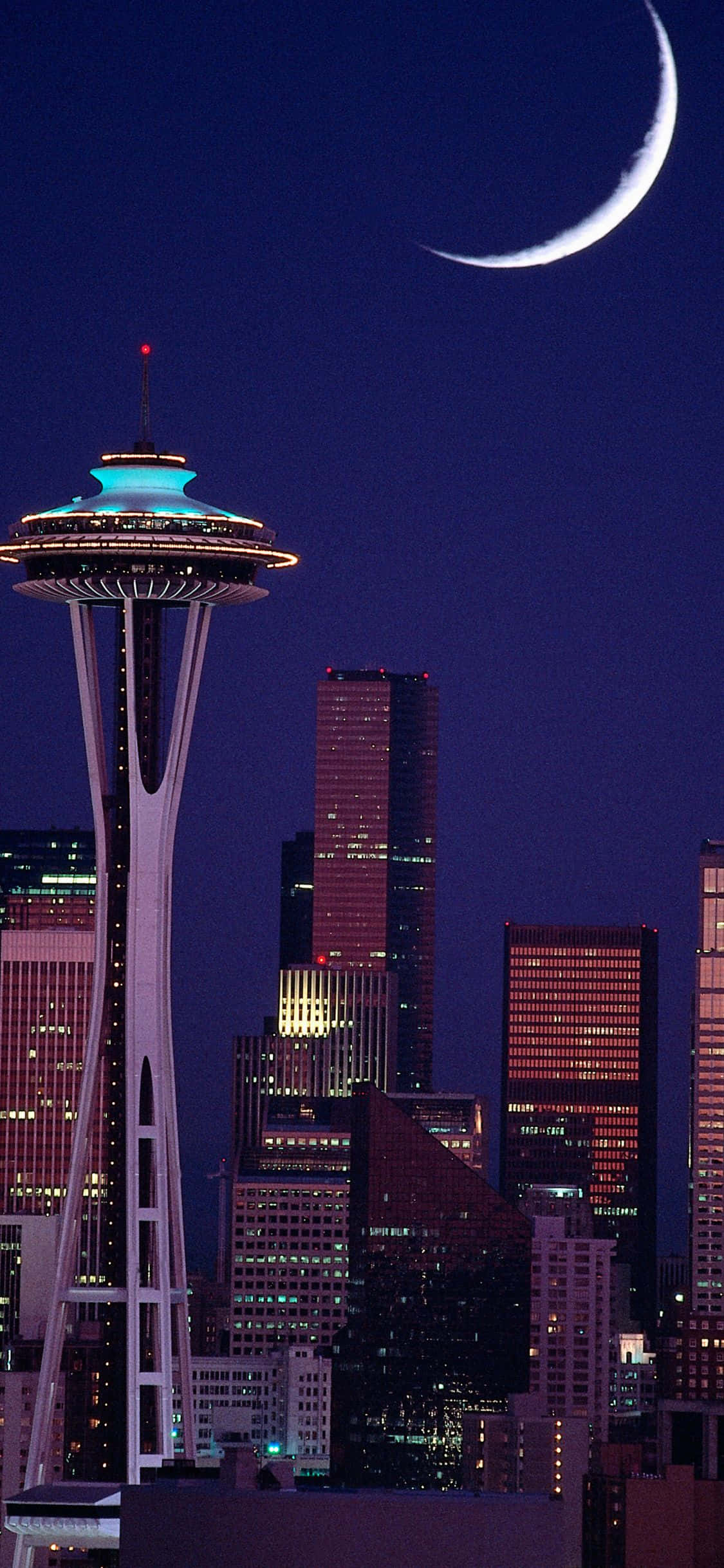 'n Boeiende uitsig oor Seattle se skyline van die waterkant af Muurpapier