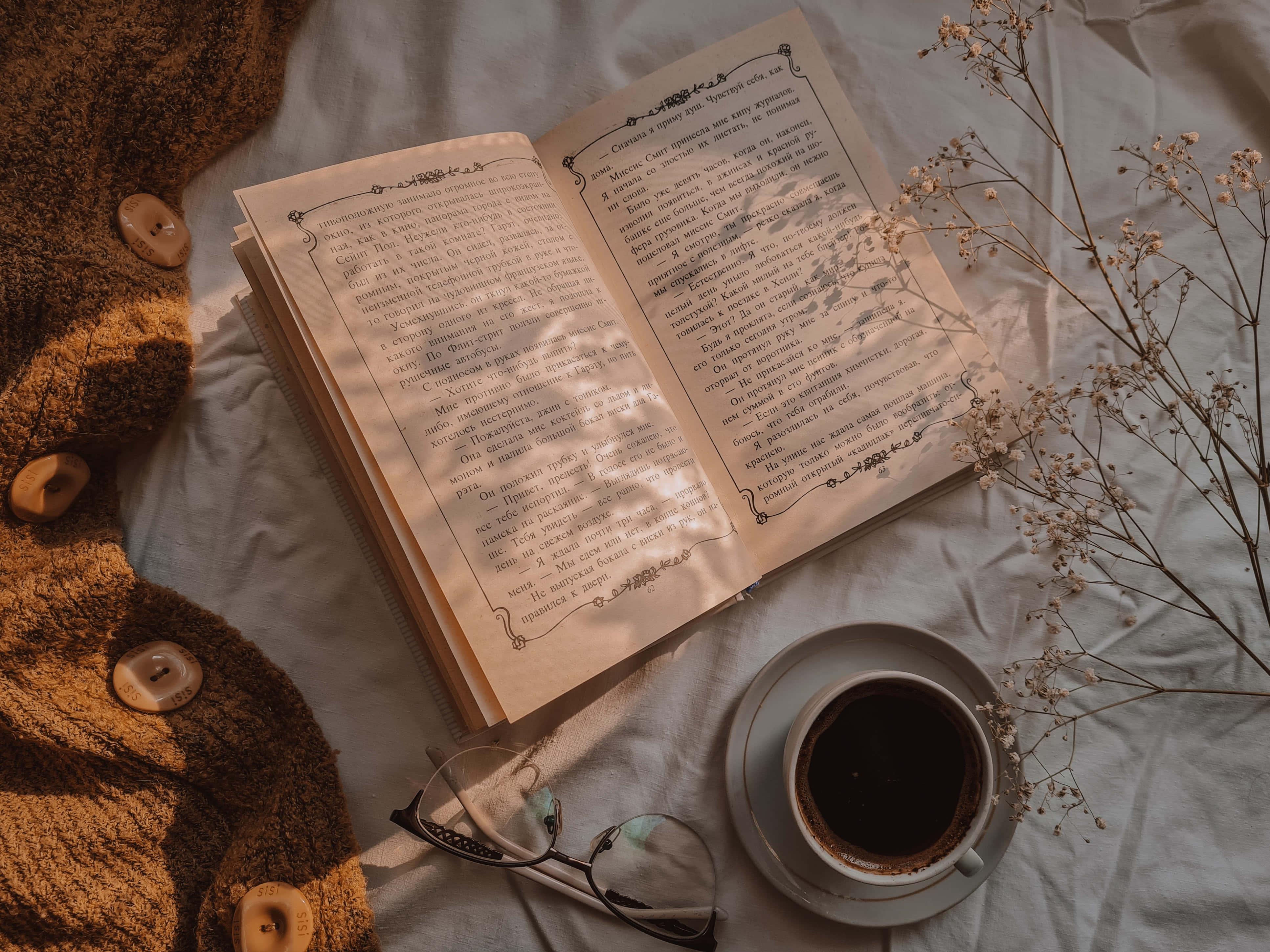 'n boek, bril en koffie op 'n bed Muurpapier