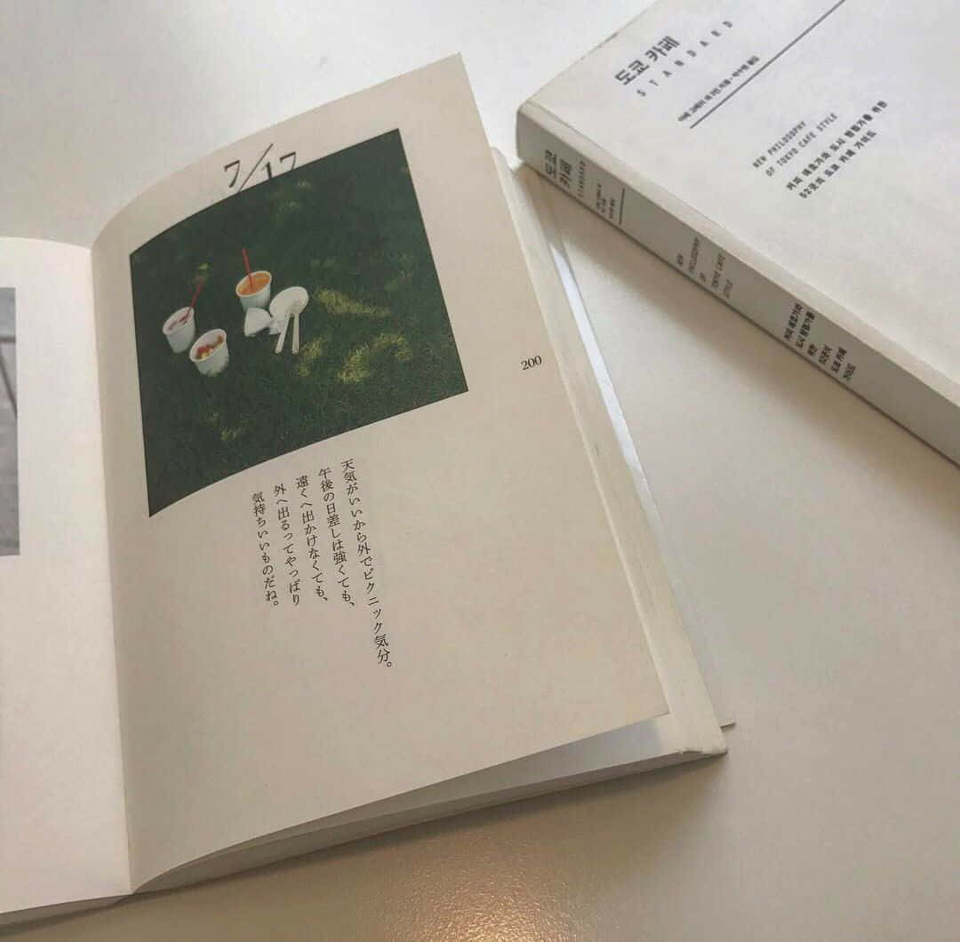 'n boek met 'n prentjie van 'n blom en 'n boek met 'n prentjie van 'n blom Muurpapier