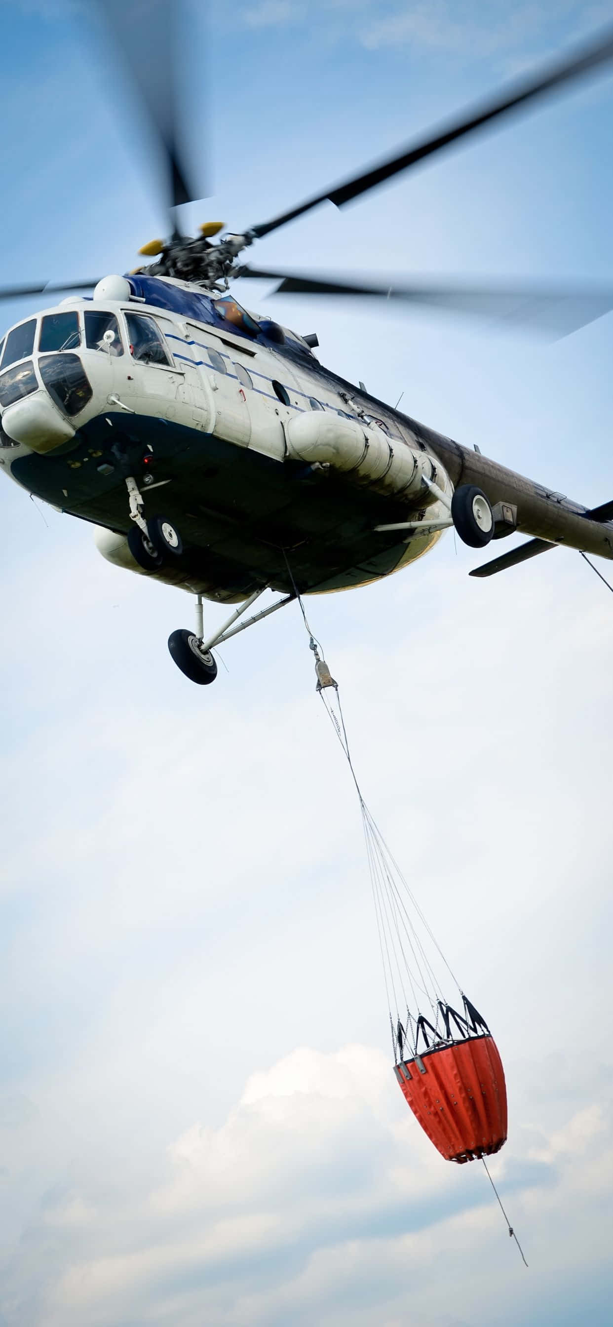 'n helikopter vlieg met 'n rooi sak daaraan vasgemaak Muurpapier