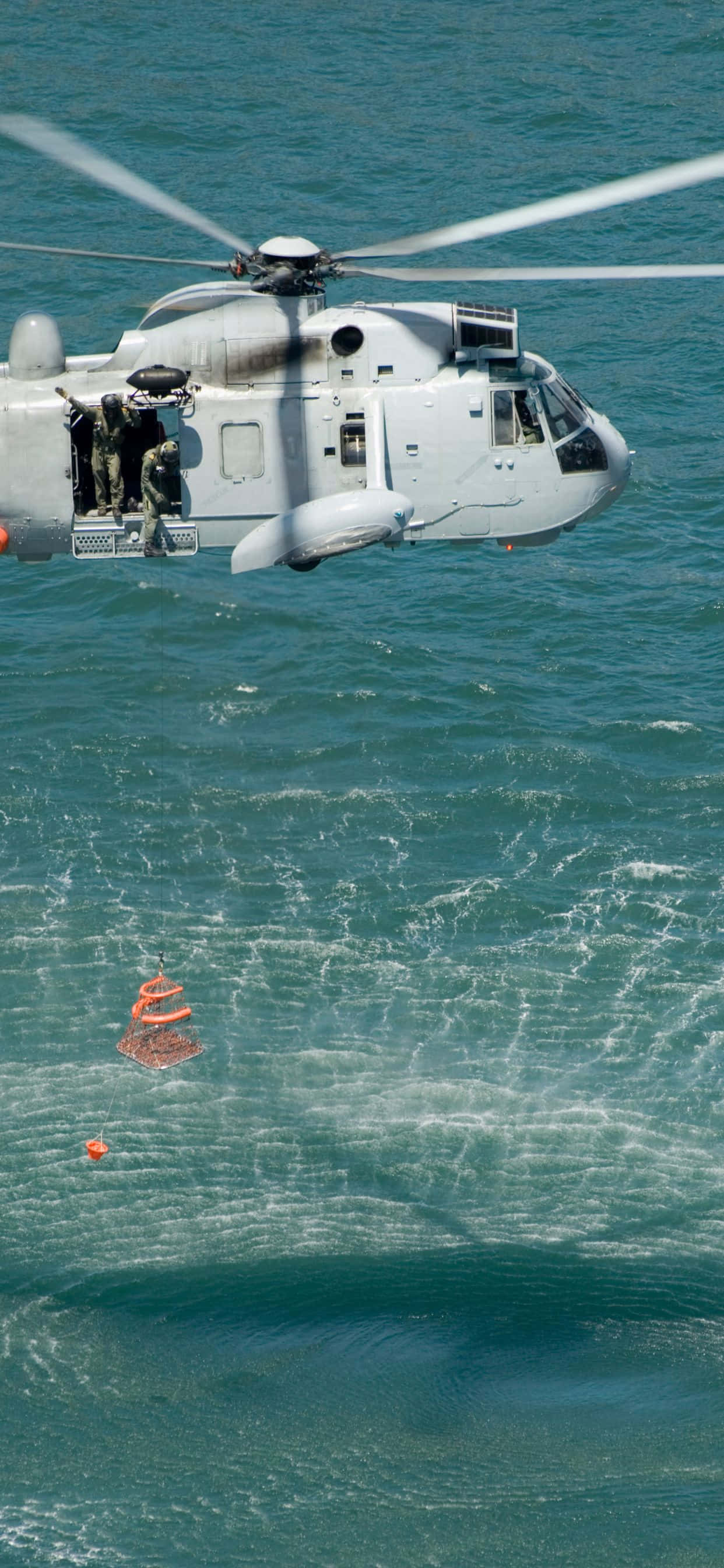 'n helikopter wat oor die water vlieg Muurpapier