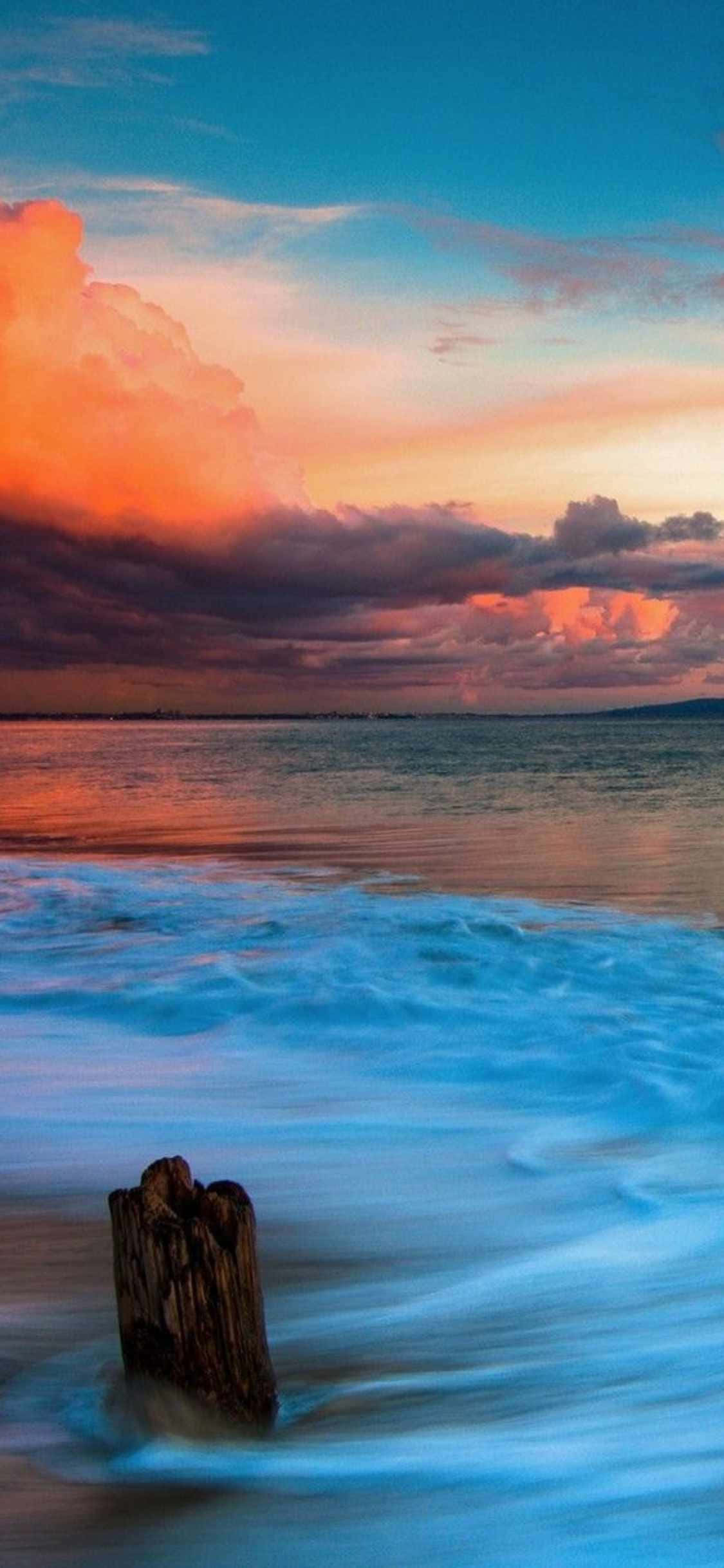'n Idilliese sonsondergang oor Malibu, Kalifornië gesien deur die lens van 'n iPhone Xs Muurpapier