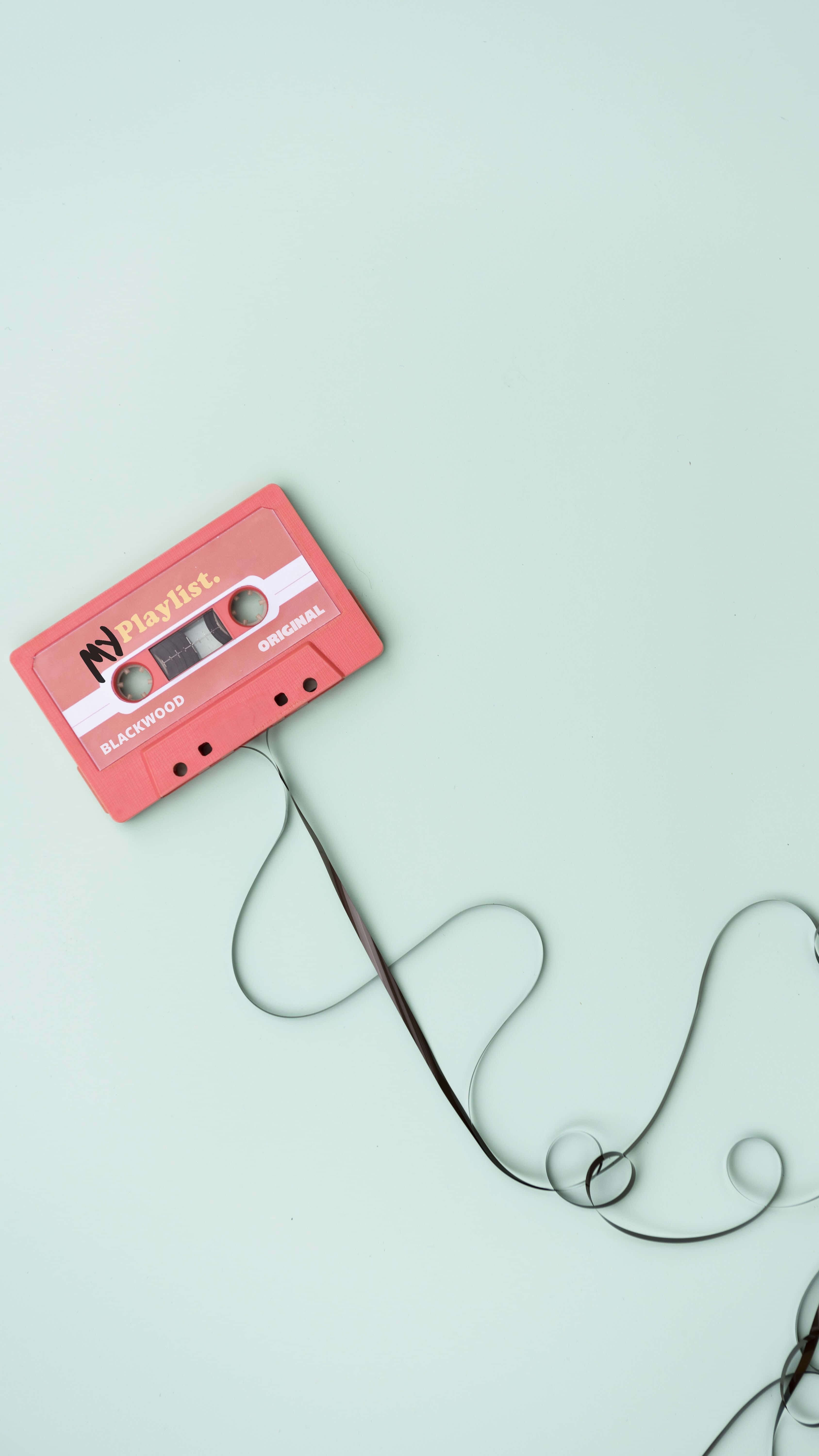 'n Kassetteband is aan 'n draad gekoppel Muurpapier