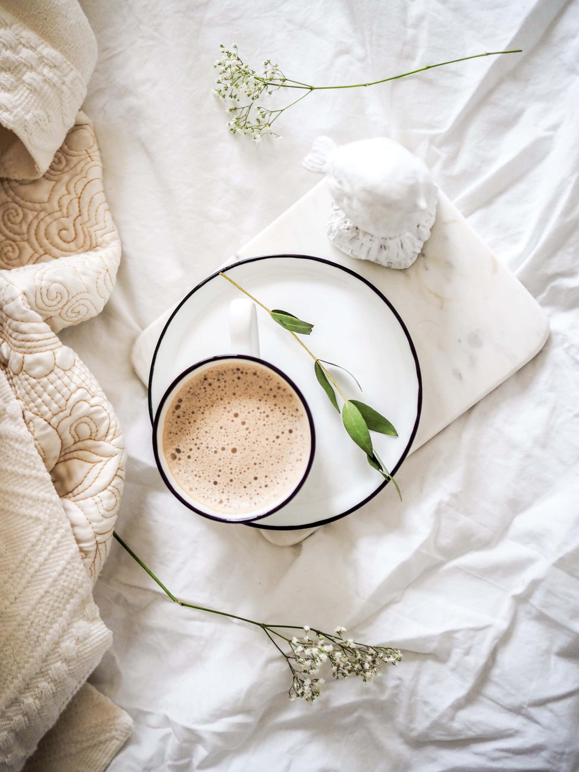 'n koppie koffie op 'n bed met blomme Muurpapier