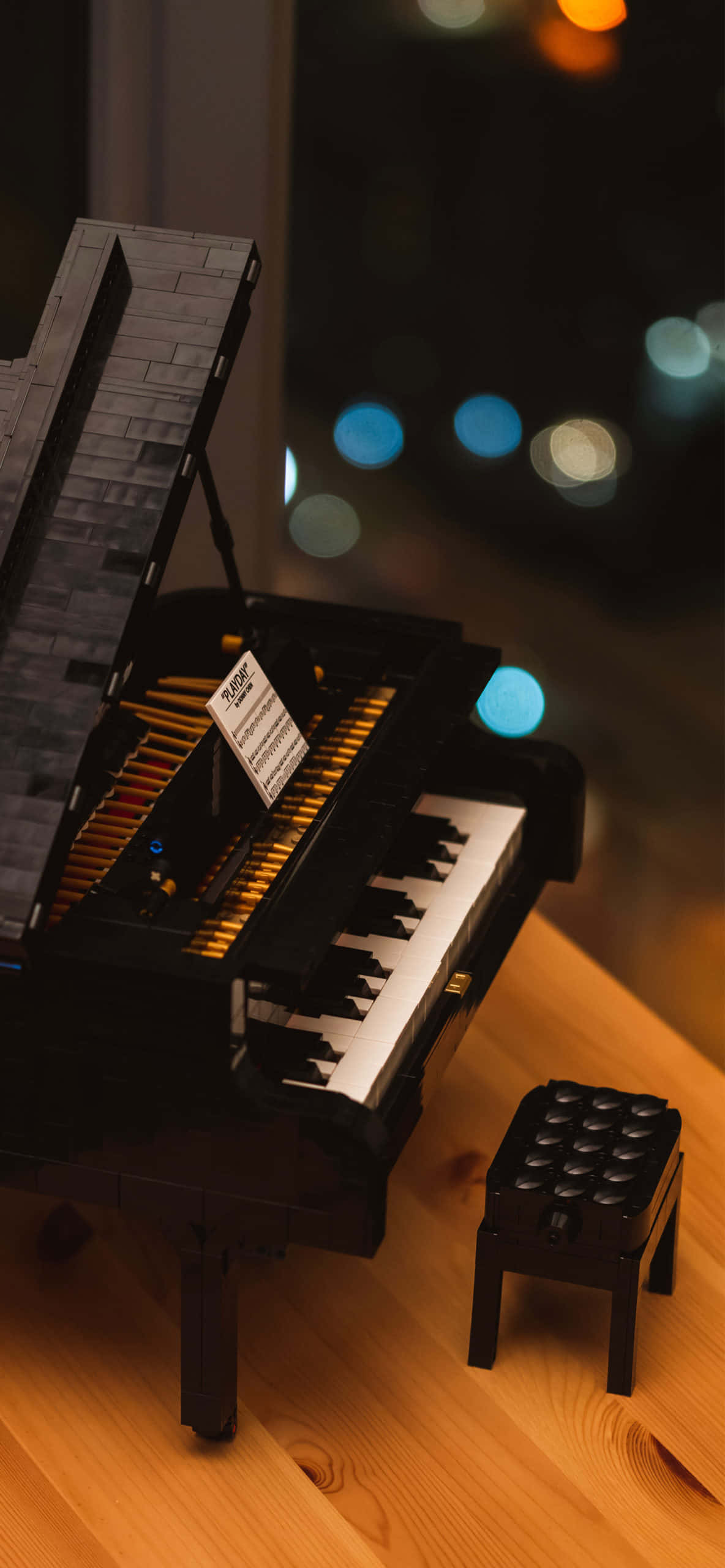 'n Lego klavier wat op 'n tafel met 'n stoel sit Muurpapier