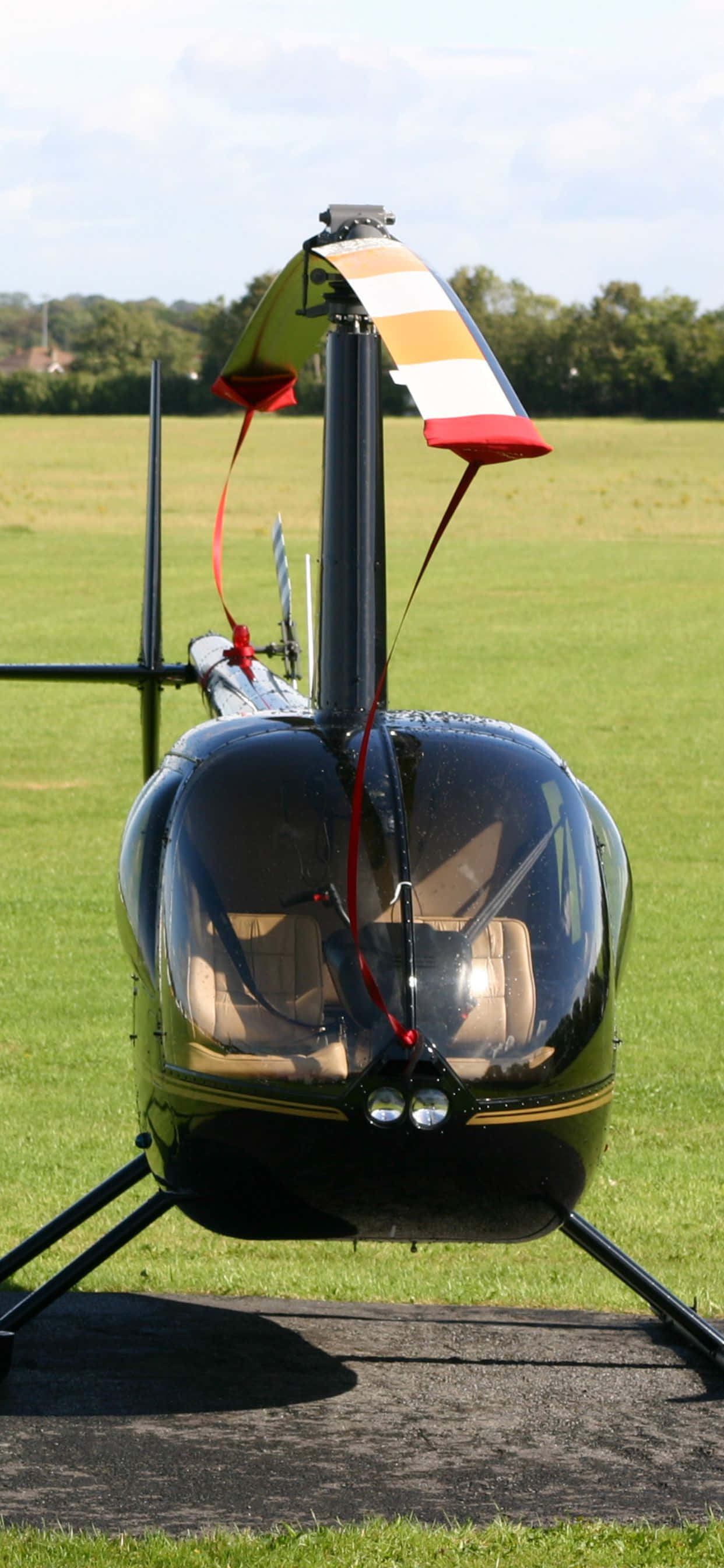 'n Lugfoto van 'n bosweide met 'n helikopter wat bo dit sweef. Muurpapier