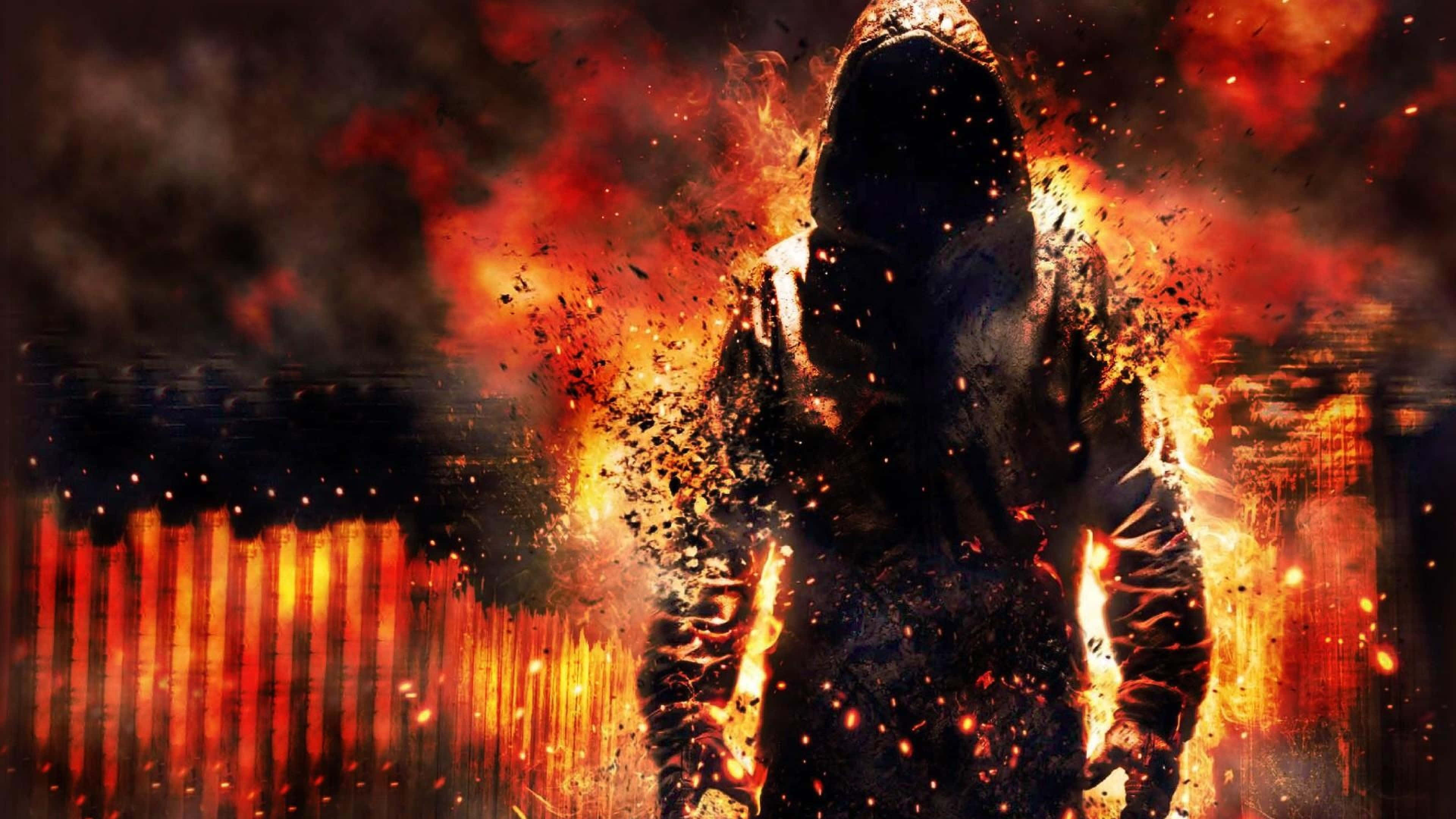 'n Man in 'n hoodie wat voor 'n vuur staan Muurpapier