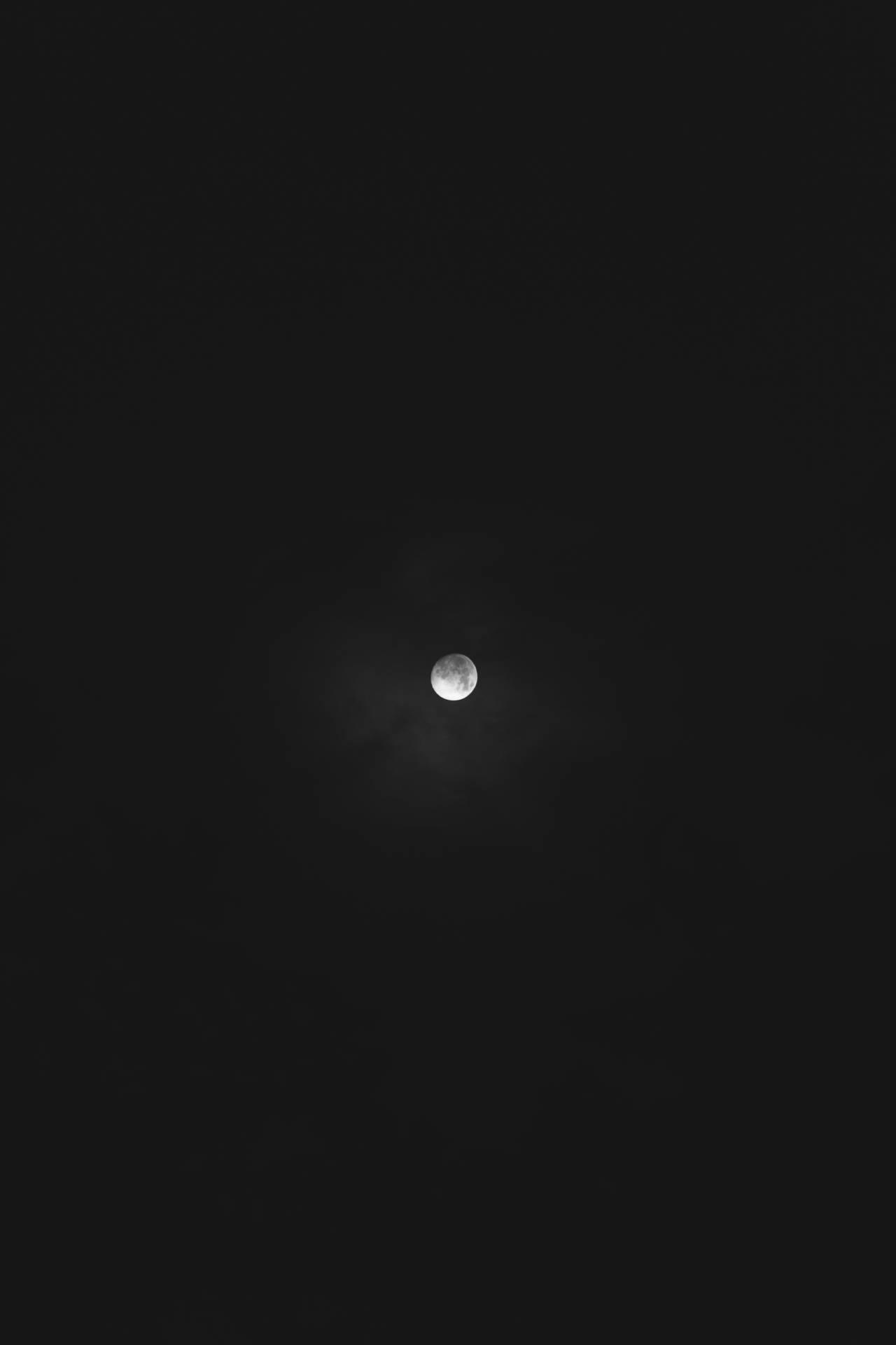 Volmaan op 'n donker middernagtelike aandhemel. Maanuitsig van onder af. Helder maanlig.