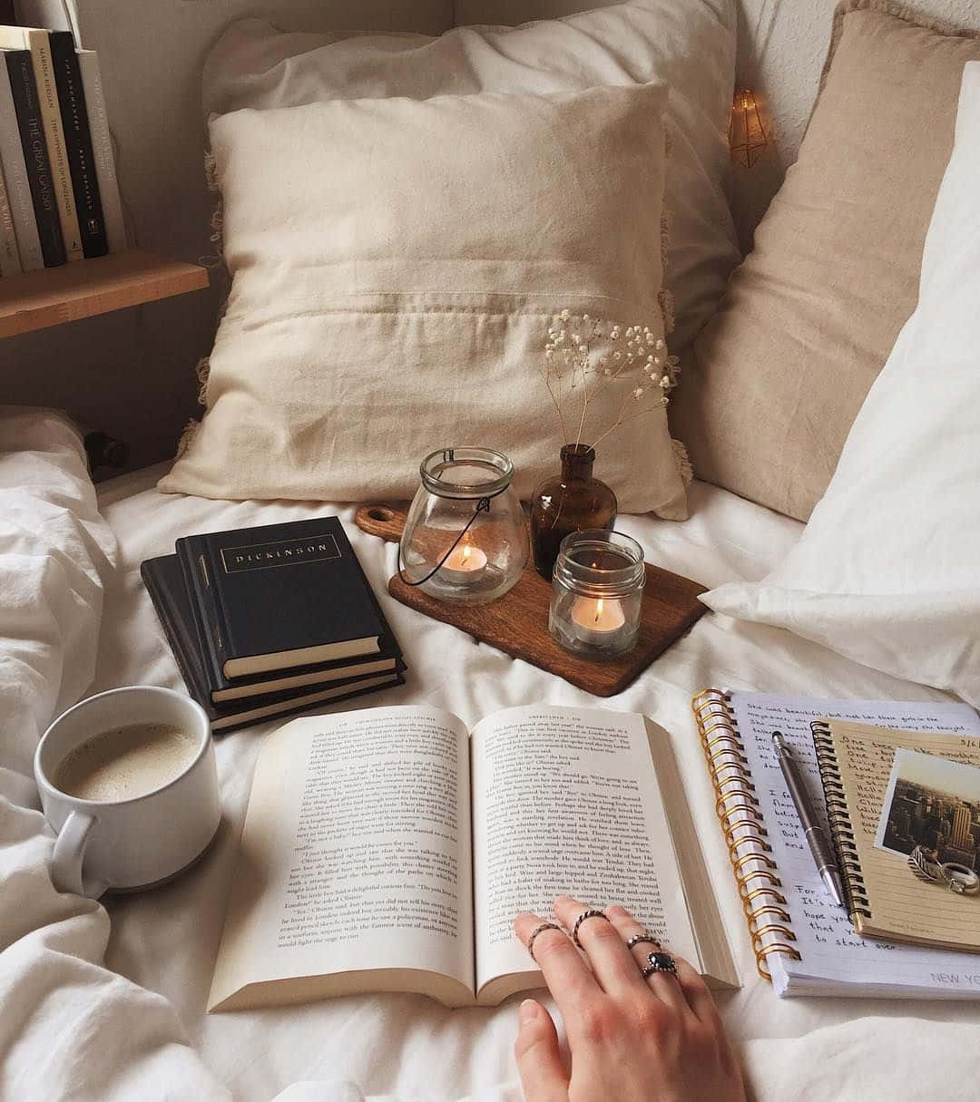 'n persoon lees 'n boek op 'n bed met kerse Muurpapier