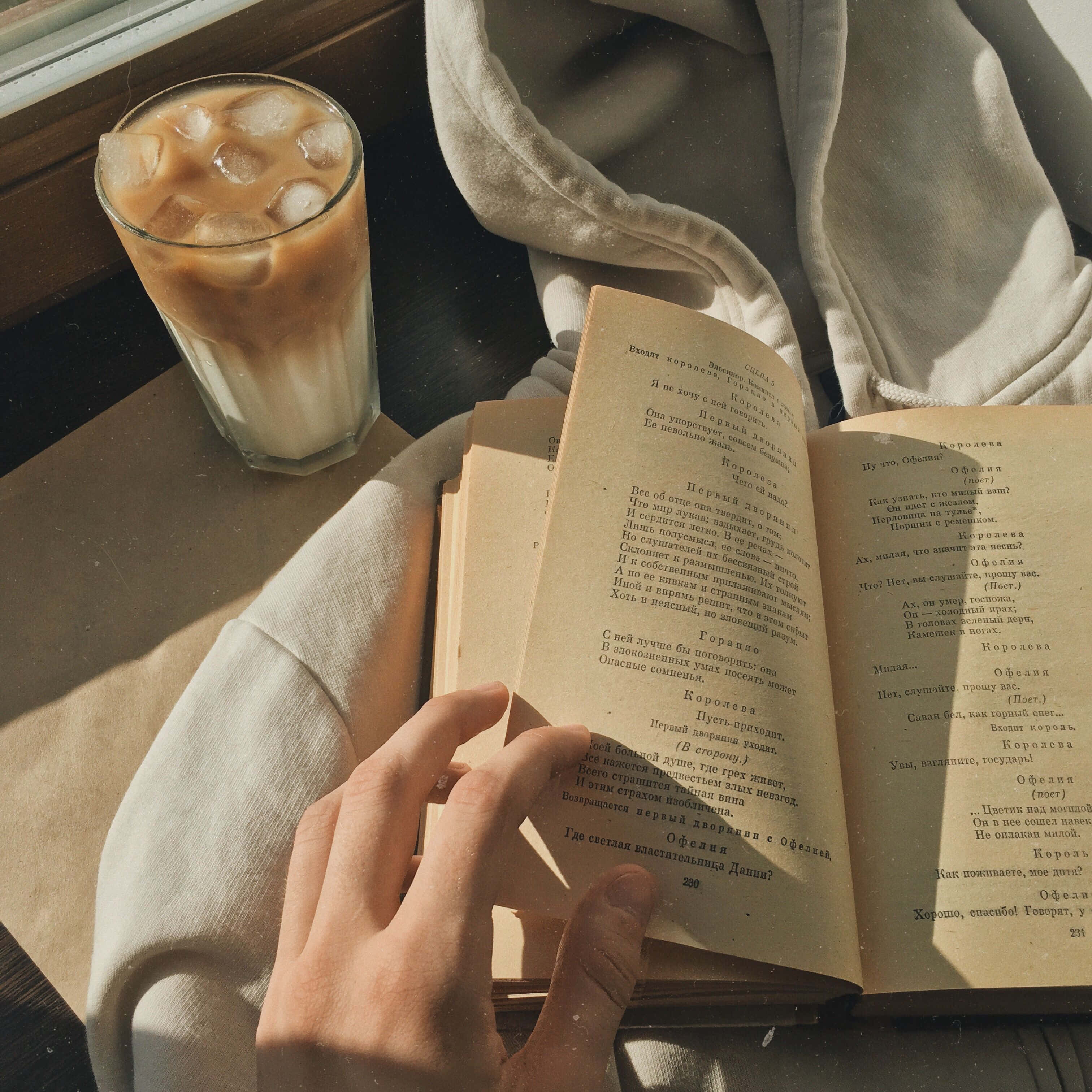 'n persoon wat 'n boek lees met 'n koppie koffie Muurpapier