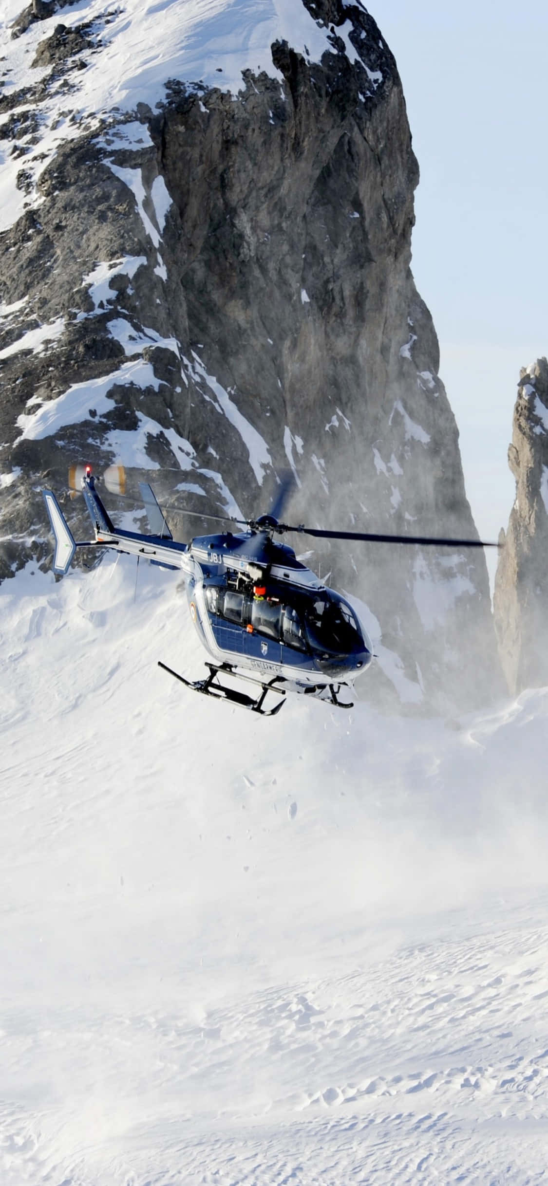 Asemrowende uitsig van Helikopters oor 'n pragtige landskap, vasgevang op 'n iPhone Xs Muurpapier