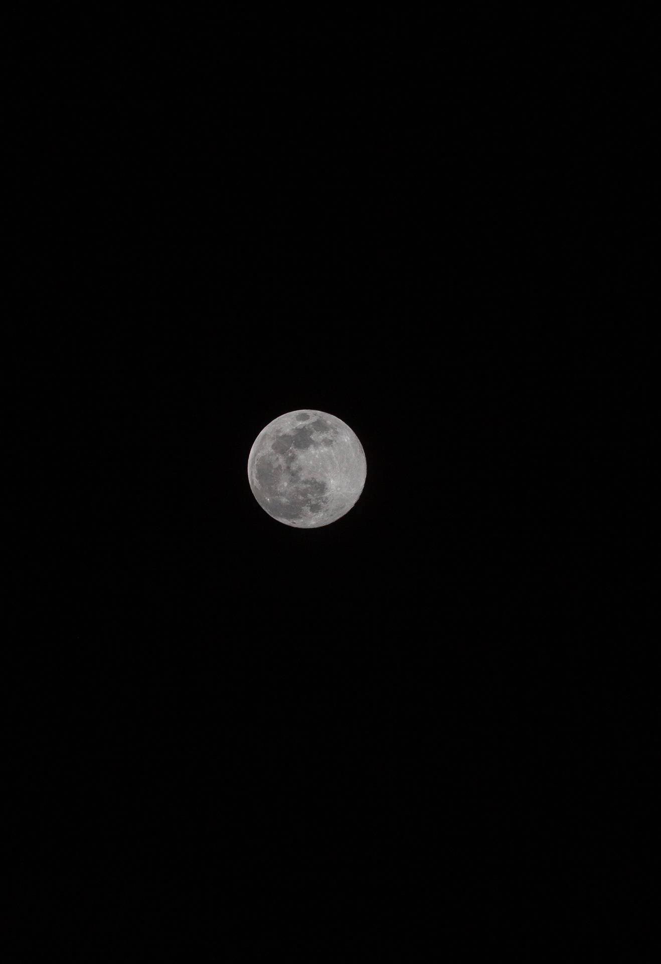 Volmaan wat helder skyn bo die swart aand-middernaghemel. Maan en satelliet-uitsig.