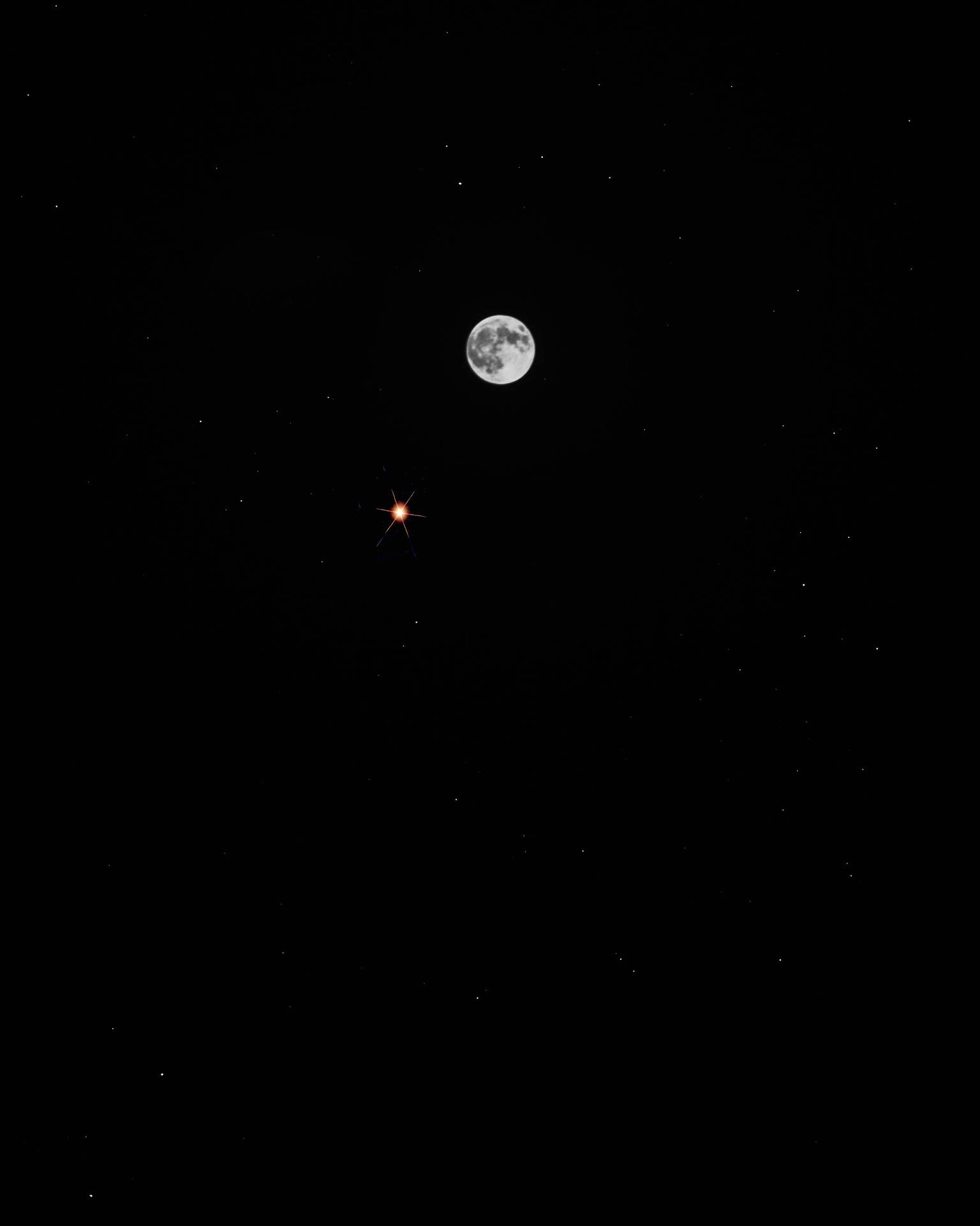 Volmaan op 'n donker middernagtelike aandhemel. Maanuitsig van onder af. Helder maanlig.