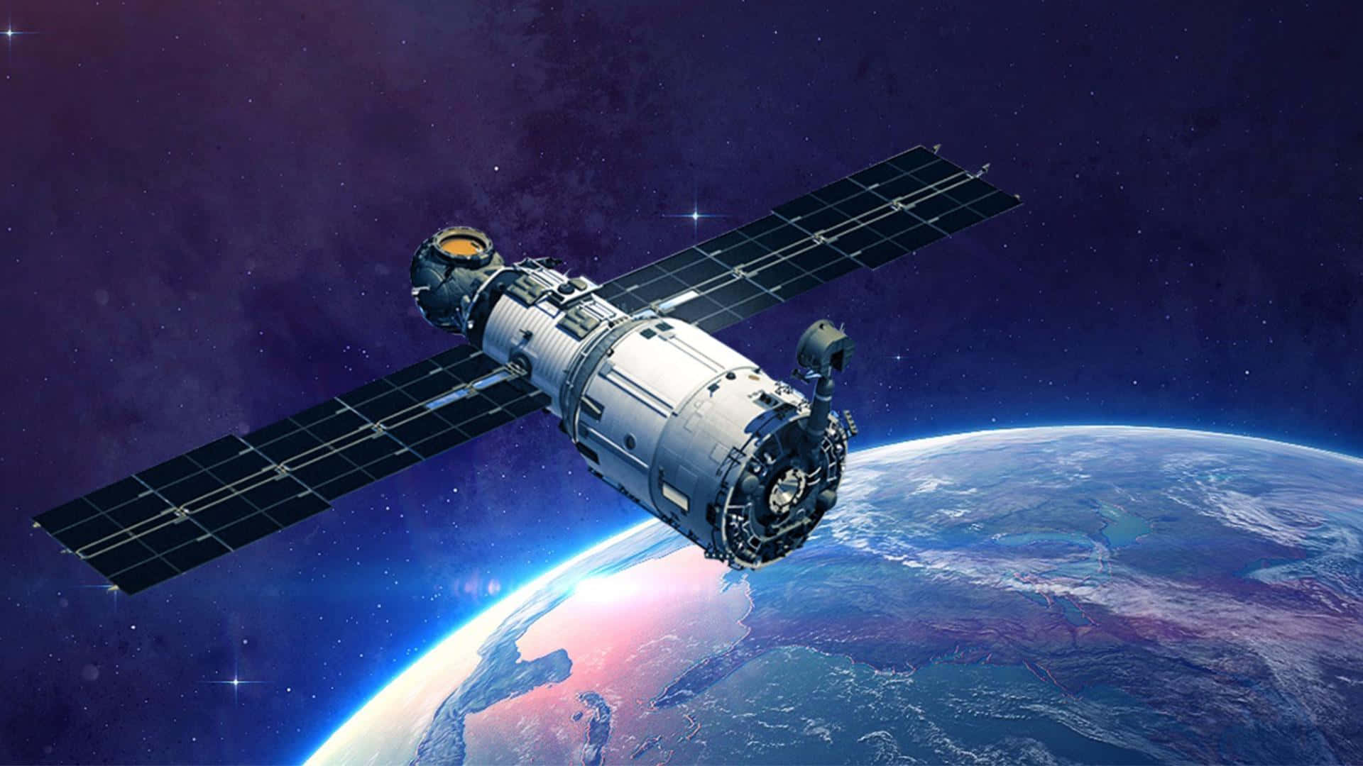 'n satelliet vlieg oor die aarde Muurpapier