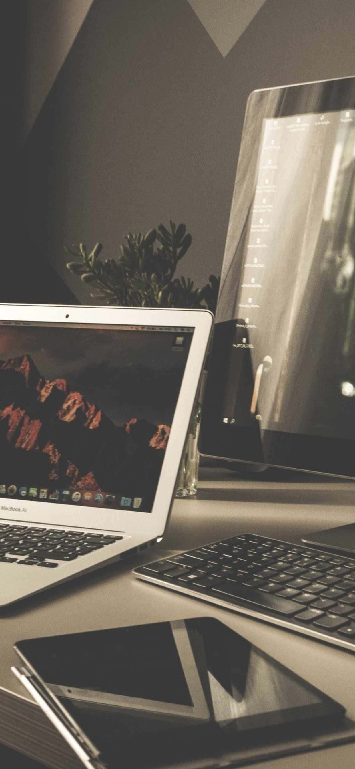 'n skootrekenaar, tablet en 'n foon op 'n lessenaar Muurpapier