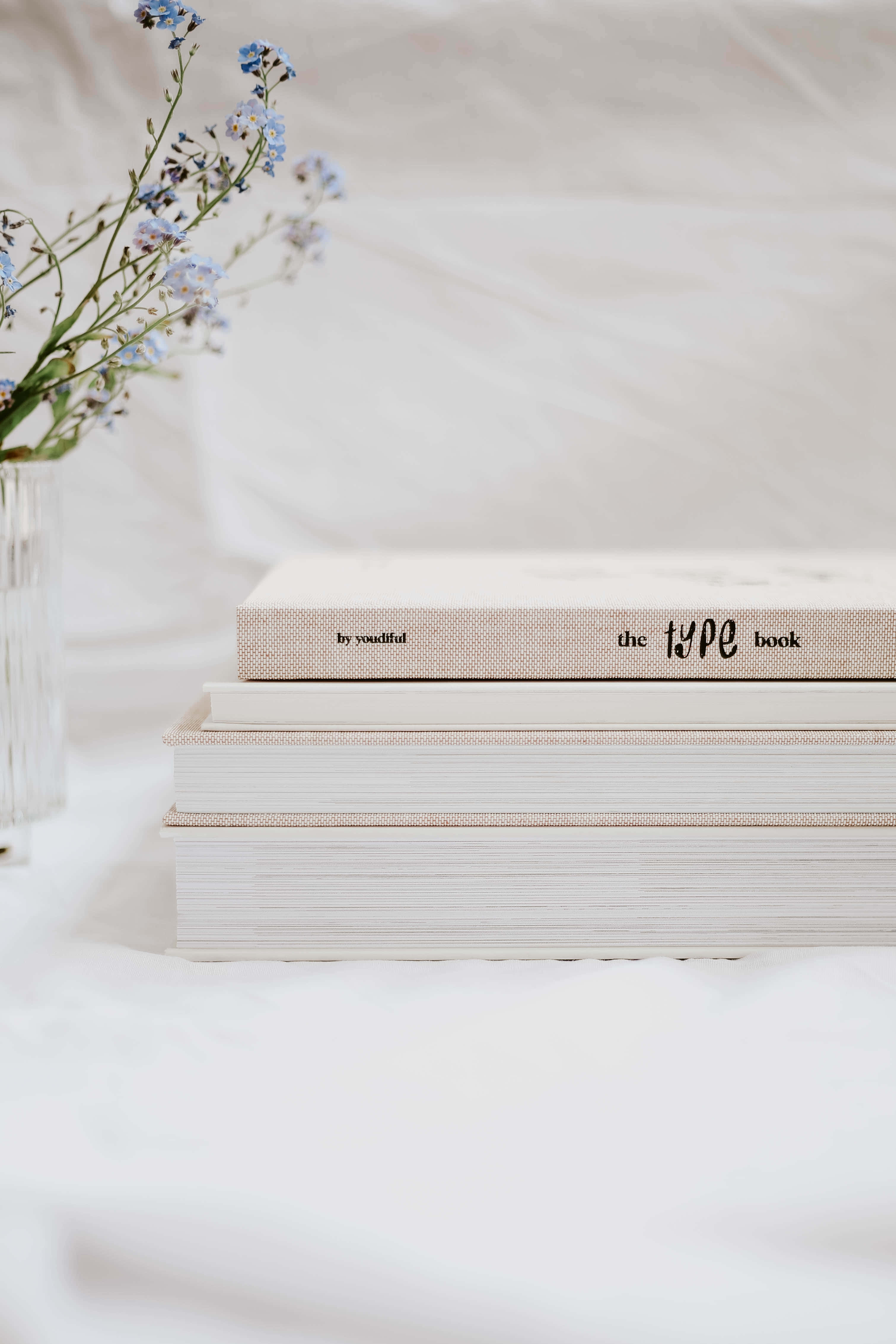 'n Stapel boeke met blomme bo-op Muurpapier