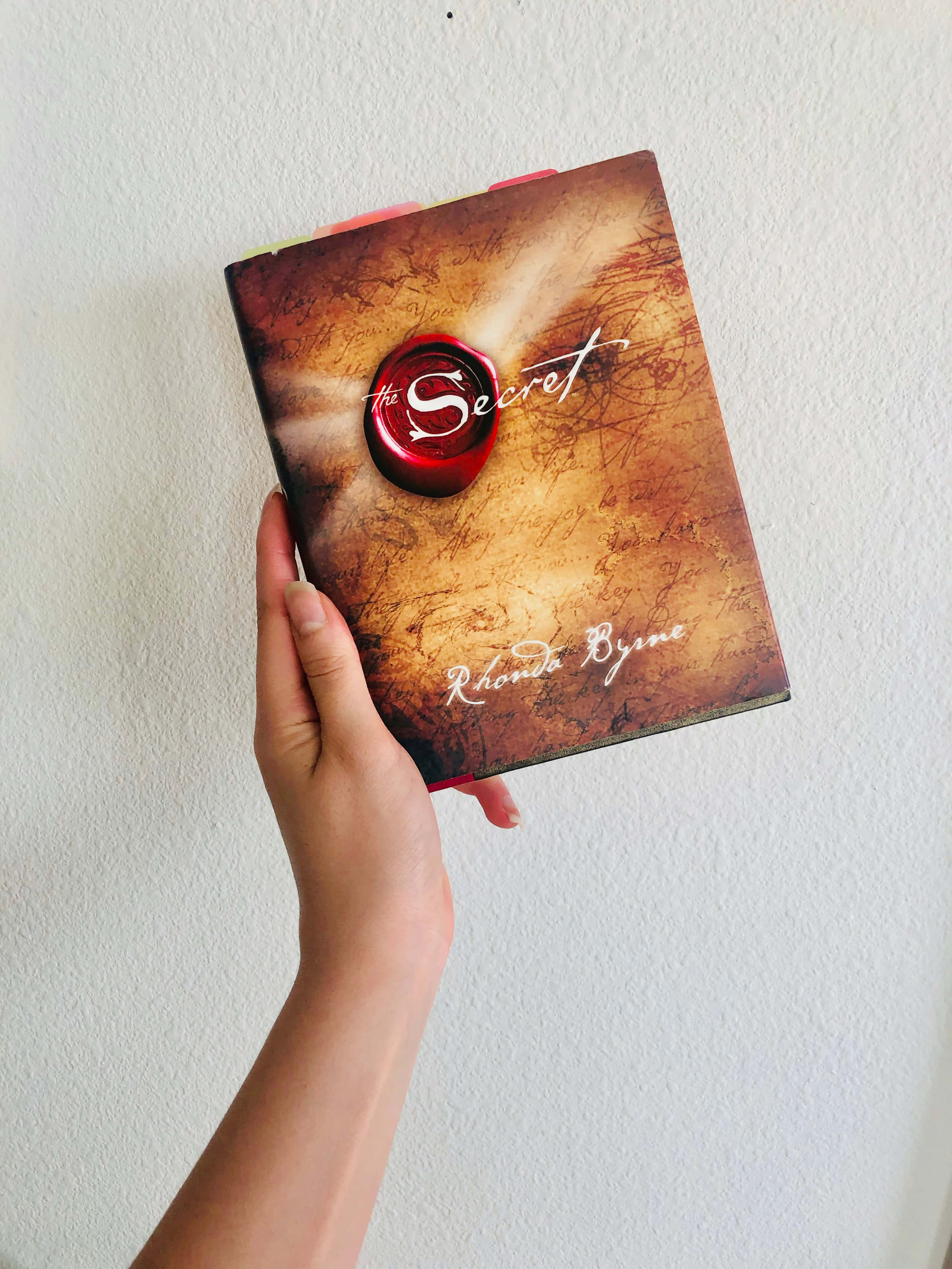 'n Stapel boeke met antieke styl-rûe bo-op 'n warm A-raam-venster. Muurpapier