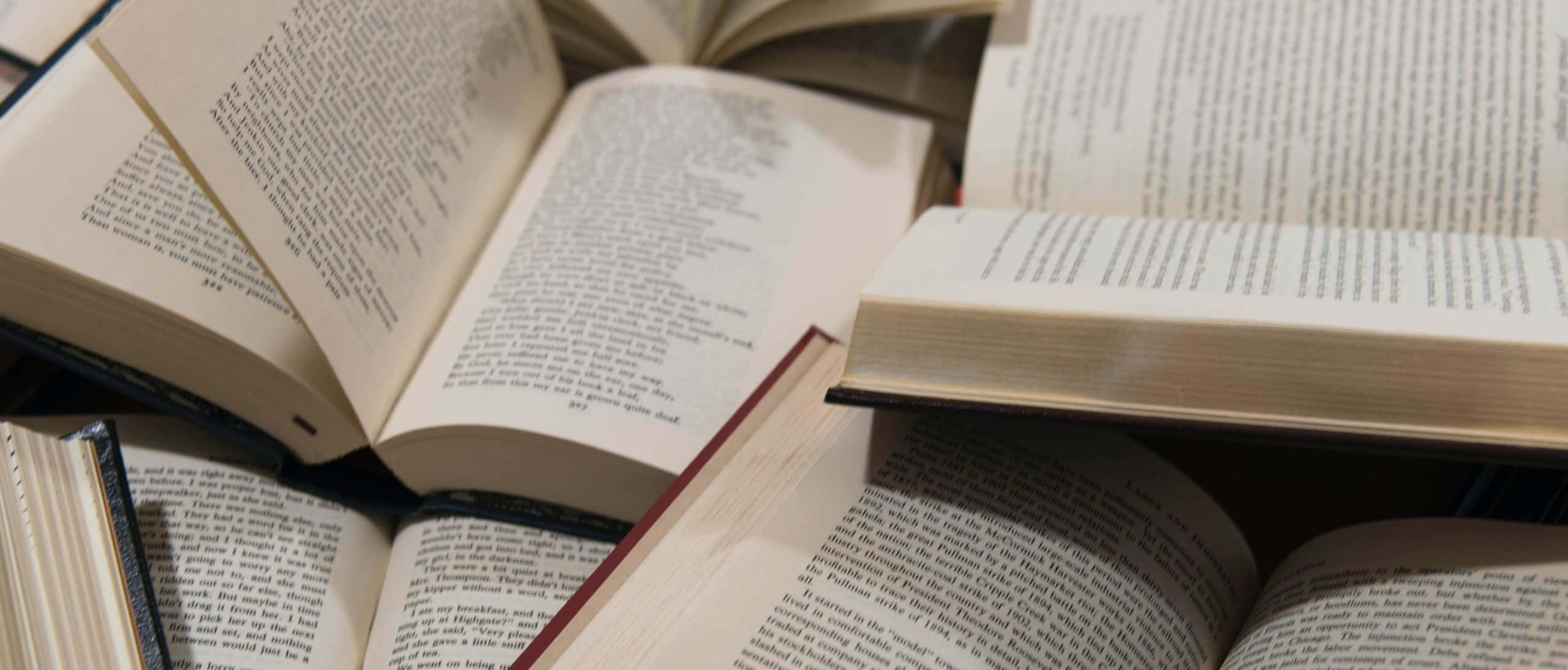 'n Stapel boeke op 'n tafel Muurpapier
