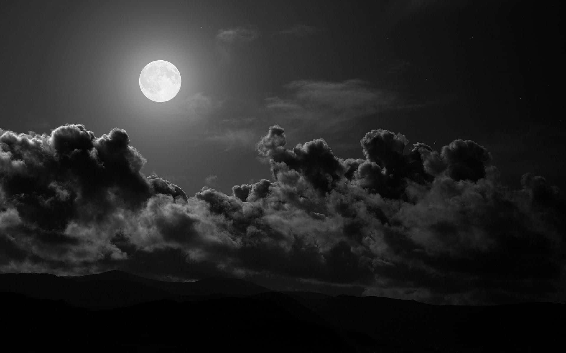 'n swart-en-wit foto van die maan en wolke Muurpapier