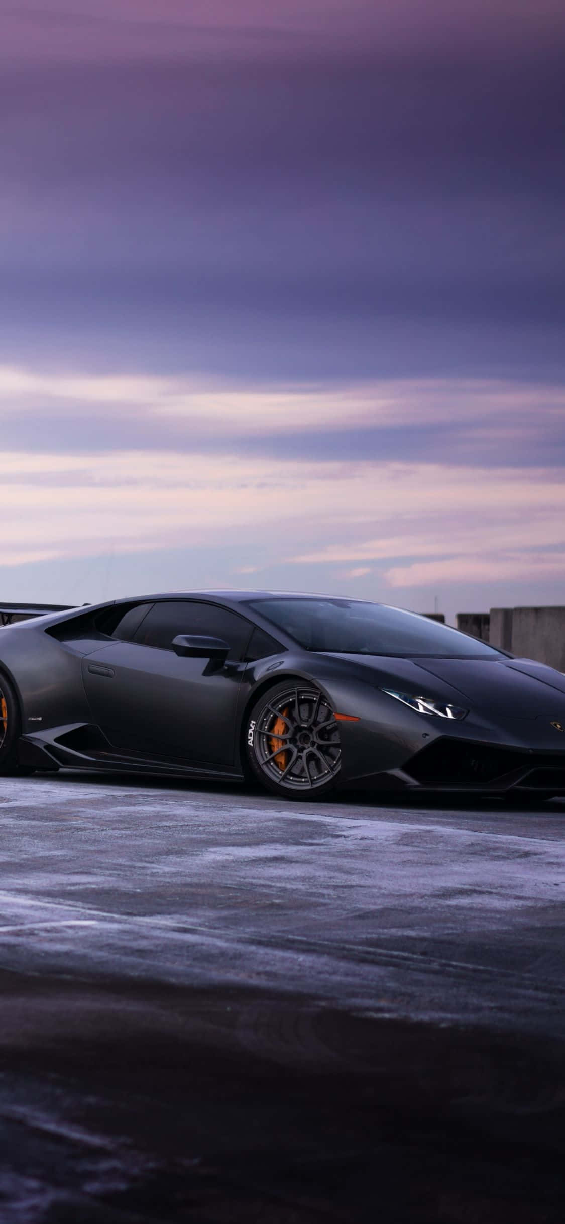 'n swart lamborghini wat op 'n sneeubedekte pad geparkeer is Muurpapier
