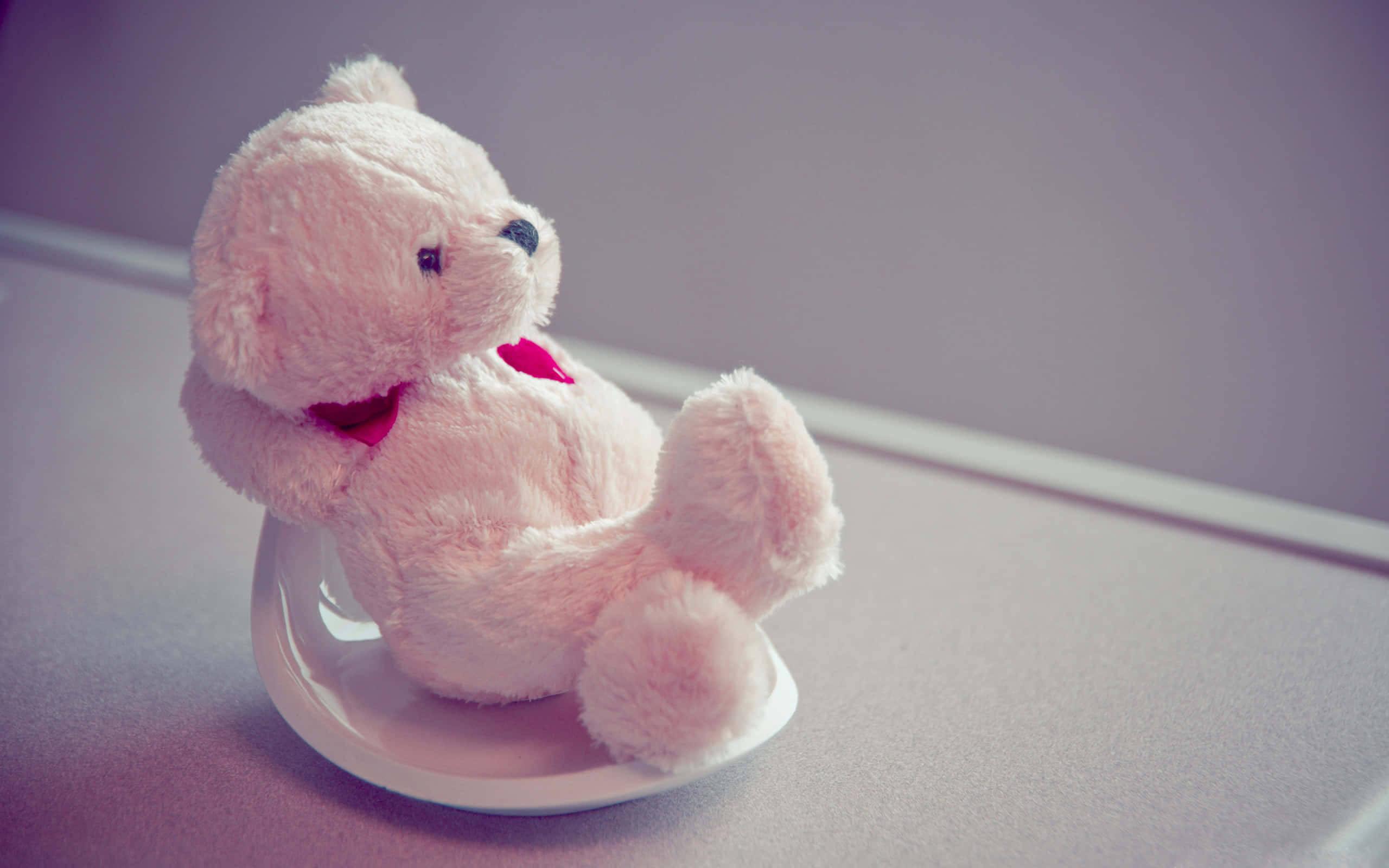 'n teddiebeer wat op 'n stoel sit Muurpapier