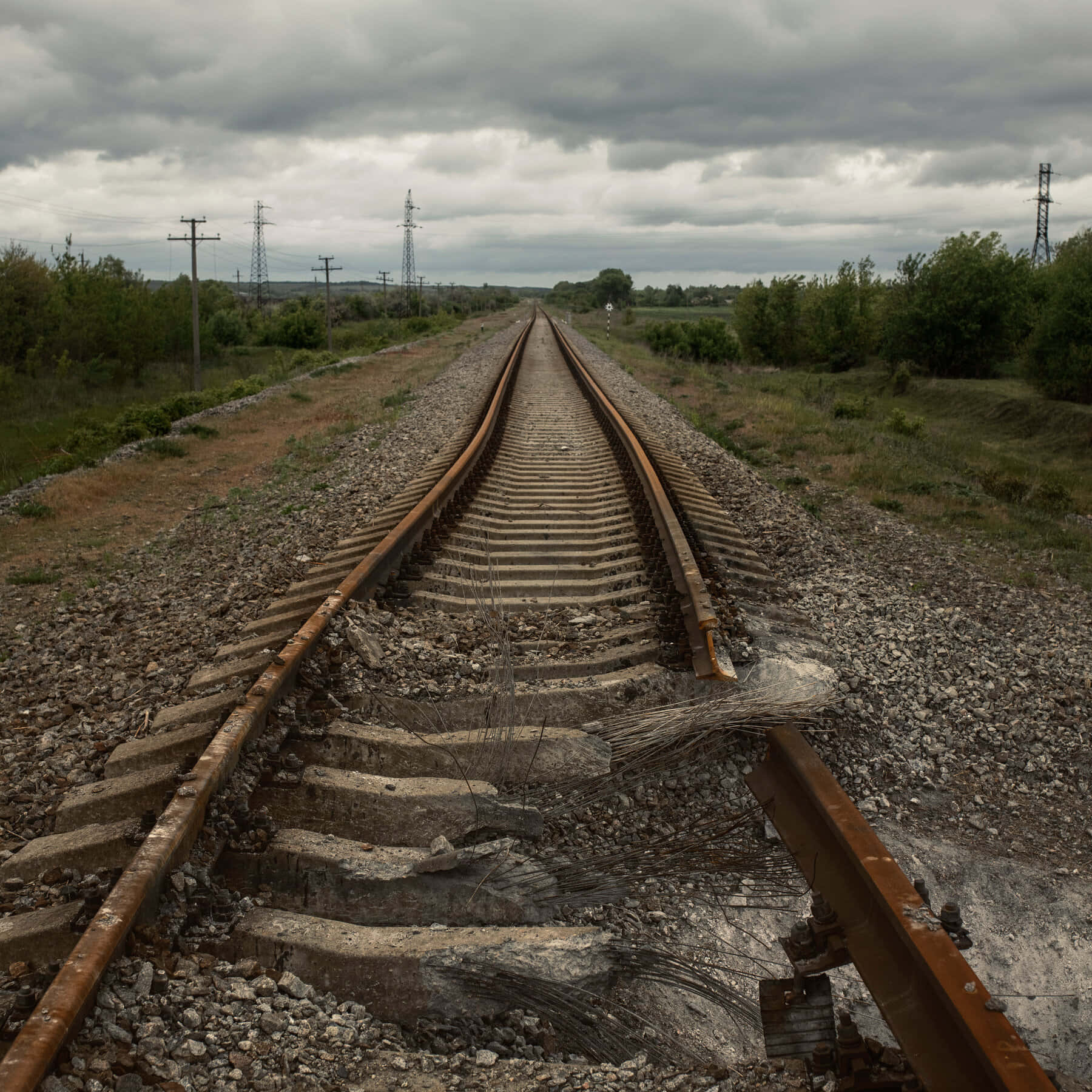 'n treinspoor in die middel van 'n veld Muurpapier