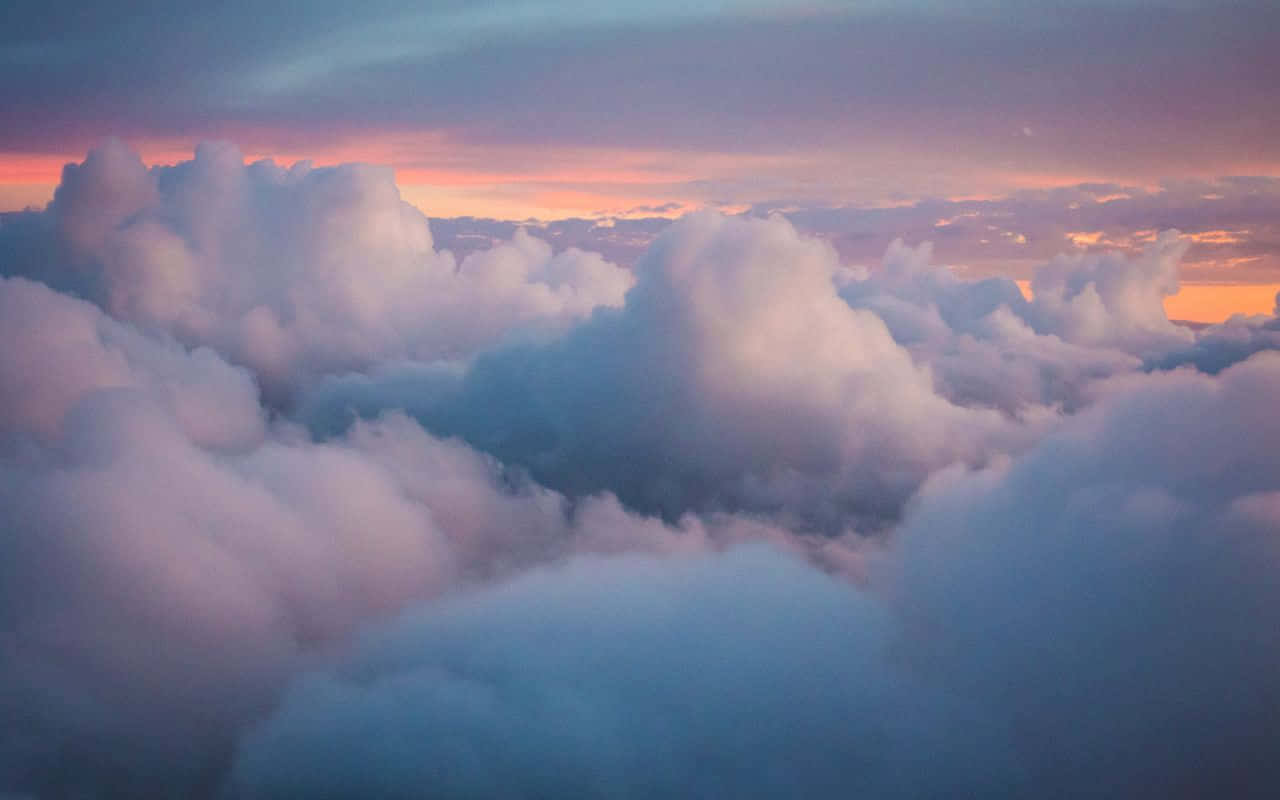 'n Uitsig op wolke vanuit 'n vliegtuig teen sononder Muurpapier